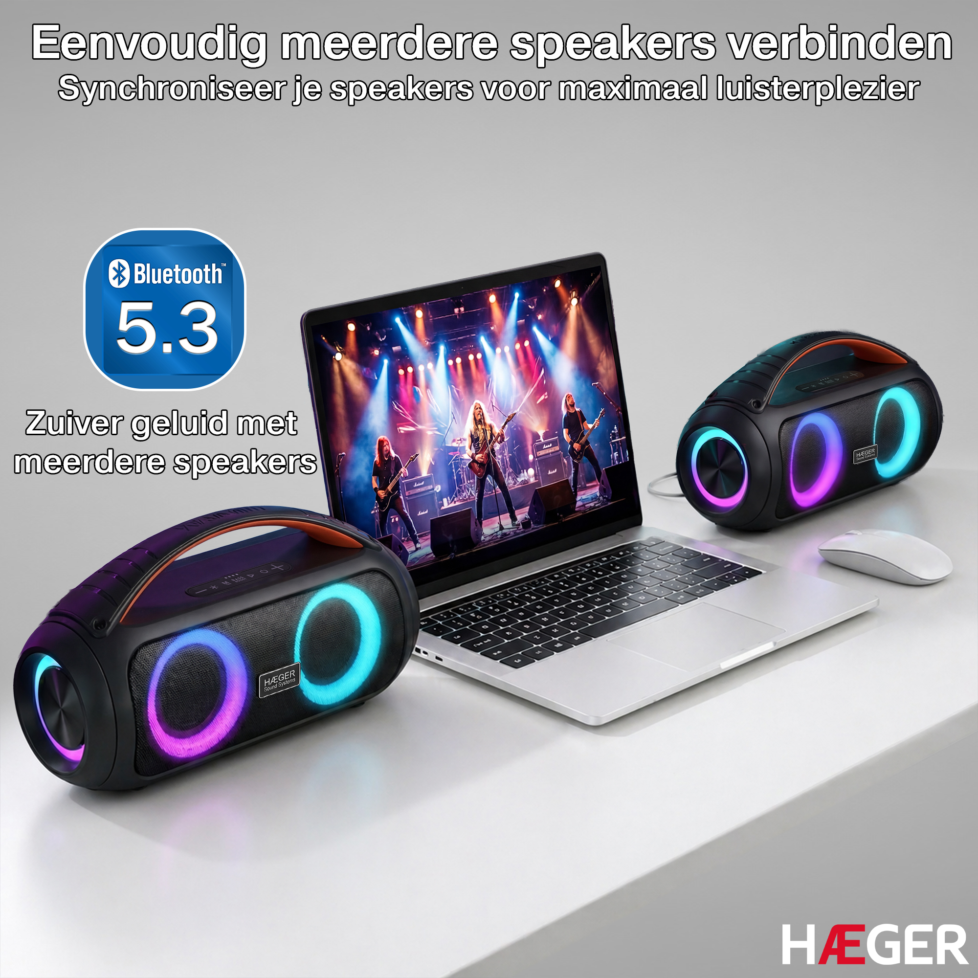 Zwei Bluetooth-Lautsprecher und ein Laptop mit einer Band auf dem Bildschirm.