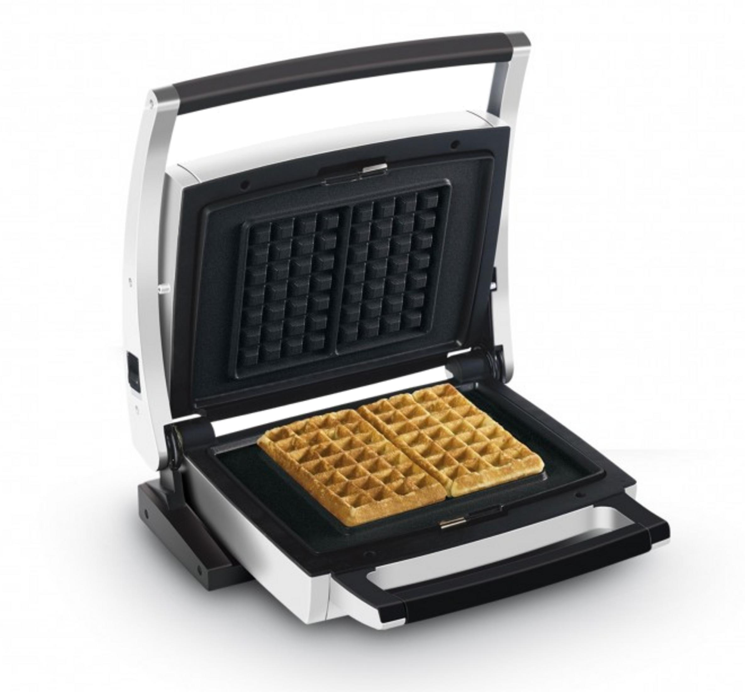 Una piastra per waffle aperta con due waffle dorati e pronti all'interno.
