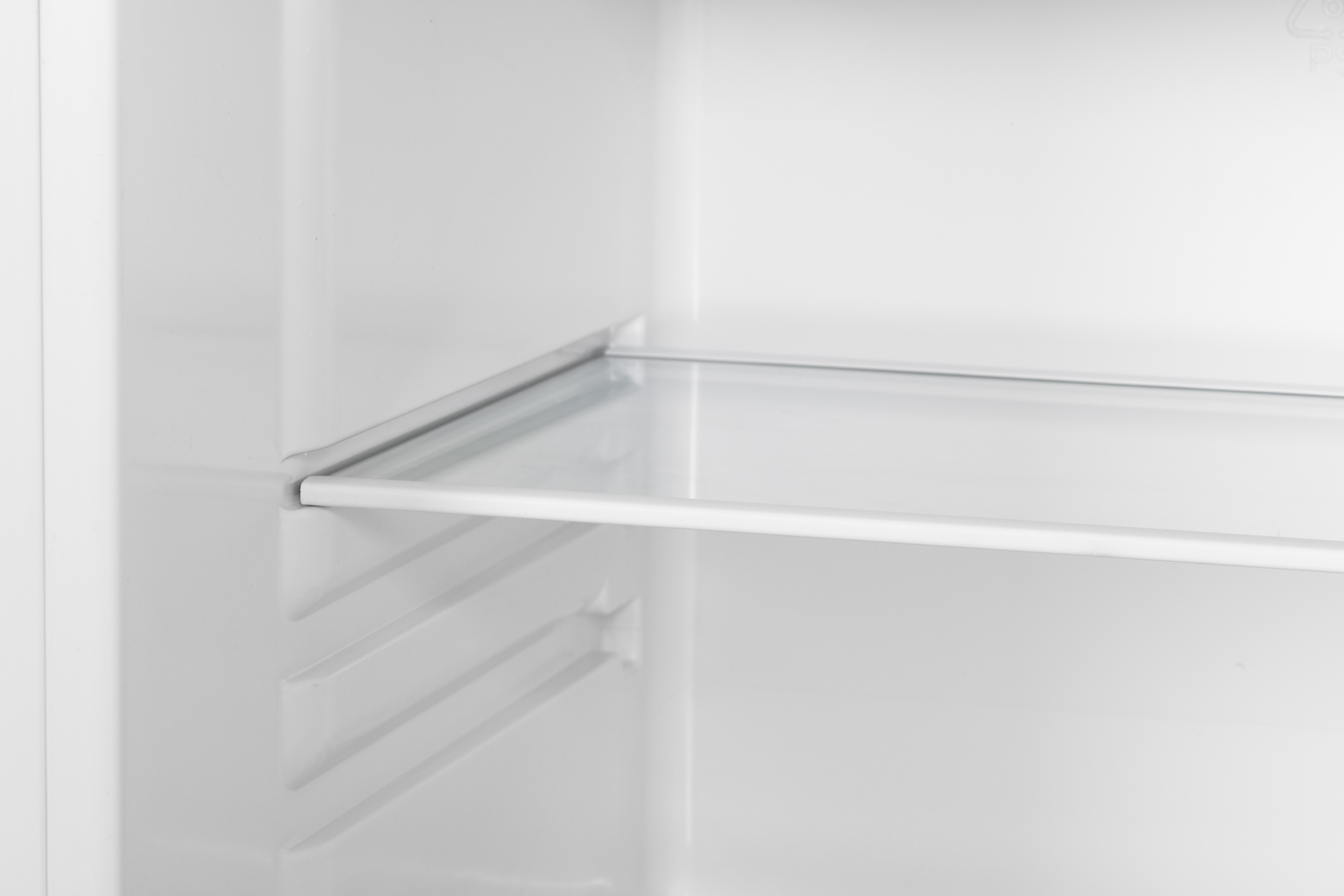 An empty refrigerator interior with a glass shelf and vertical grooves on the side.