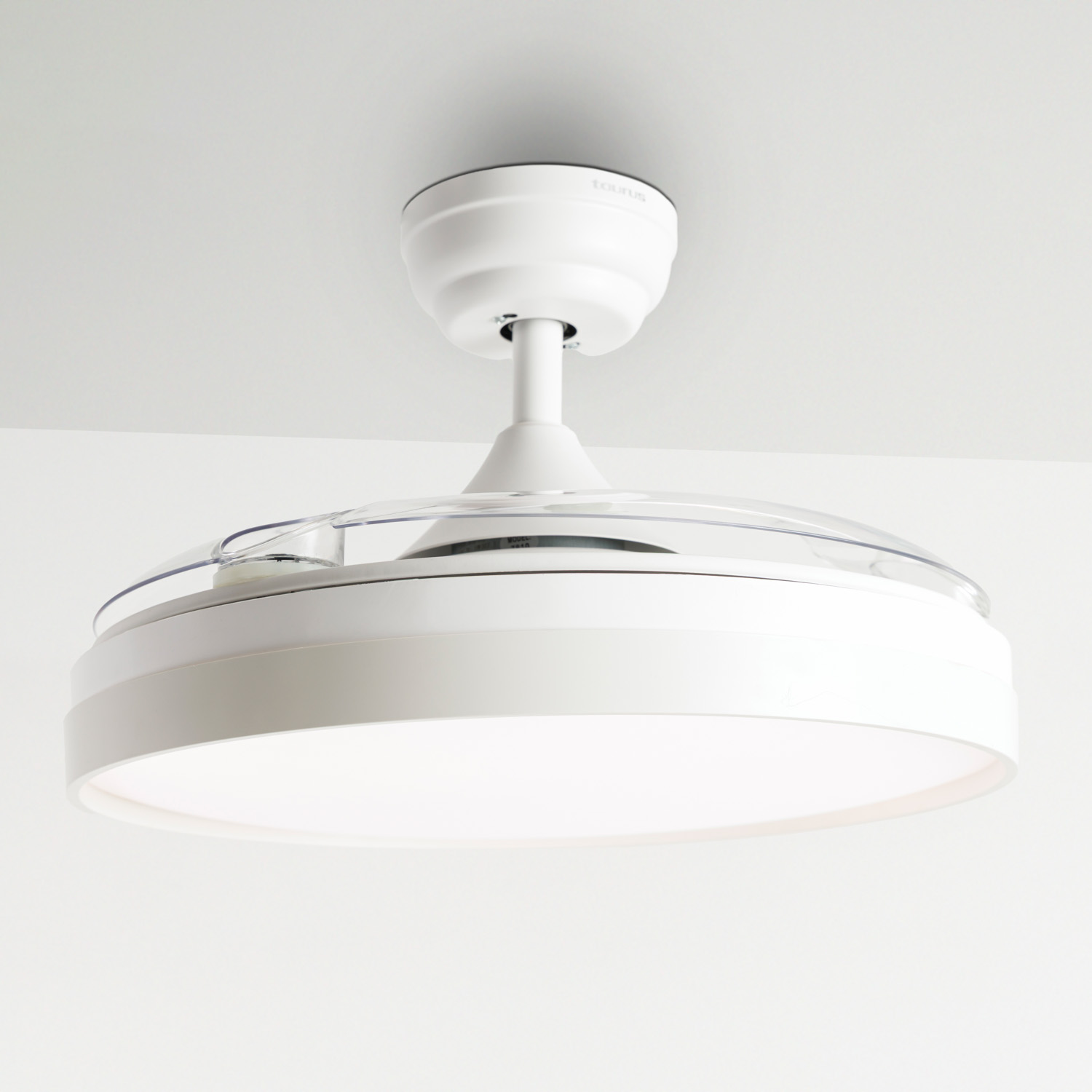 Un ventilador de techo retráctil blanco con luz está montado en un techo blanco.