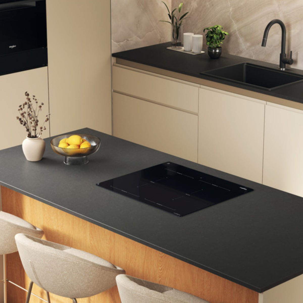 Moderne keuken met eiland, ingebouwd kookplatform, fruitschaal en zitplaatsen.