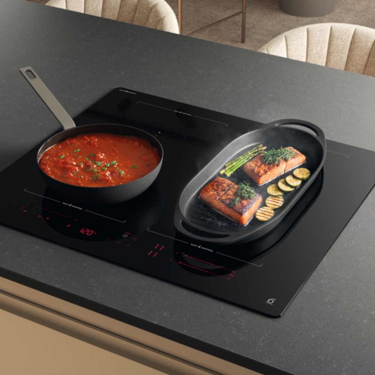Een zwart inductie kookplaat met een pan tomatensaus en een grillpan met zalm en asperges.