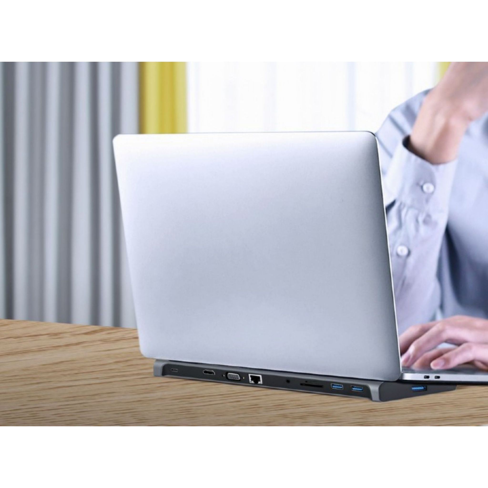 Een laptop rust op een docking station met meerdere poorten.