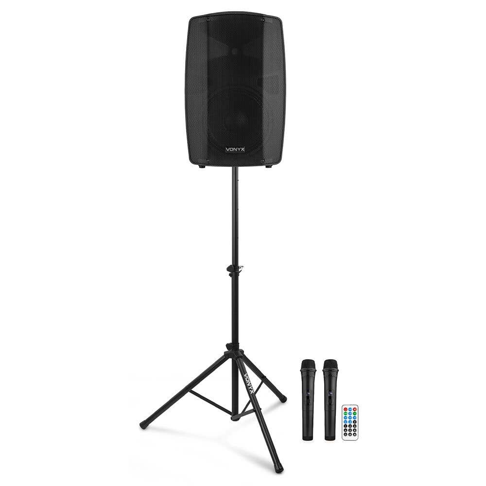 Altavoz negro sobre soporte con dos micrófonos y mando a distancia.