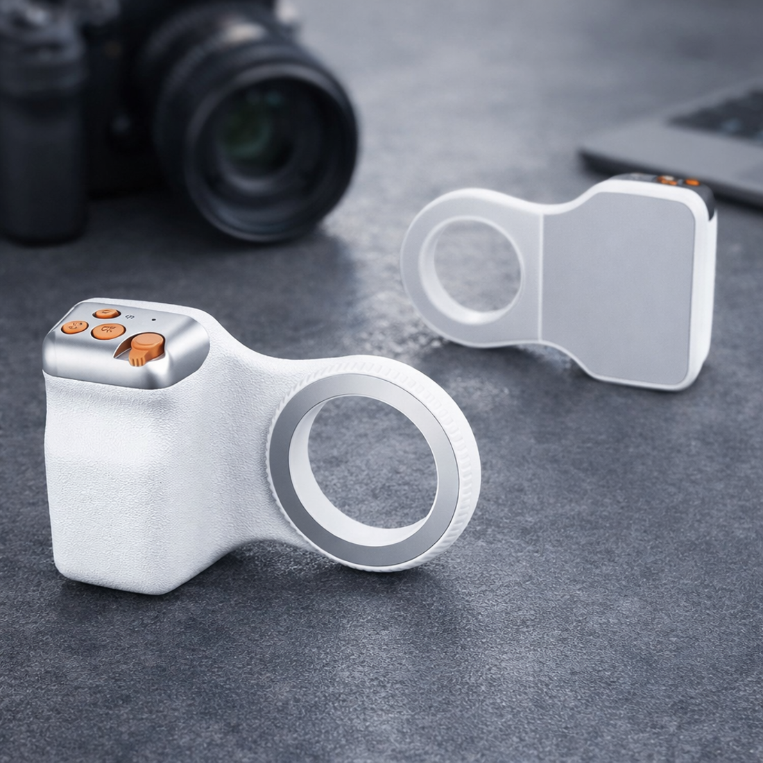 Dos accesorios de cámara blancos con botones naranjas sobre superficie oscura junto a cámara.