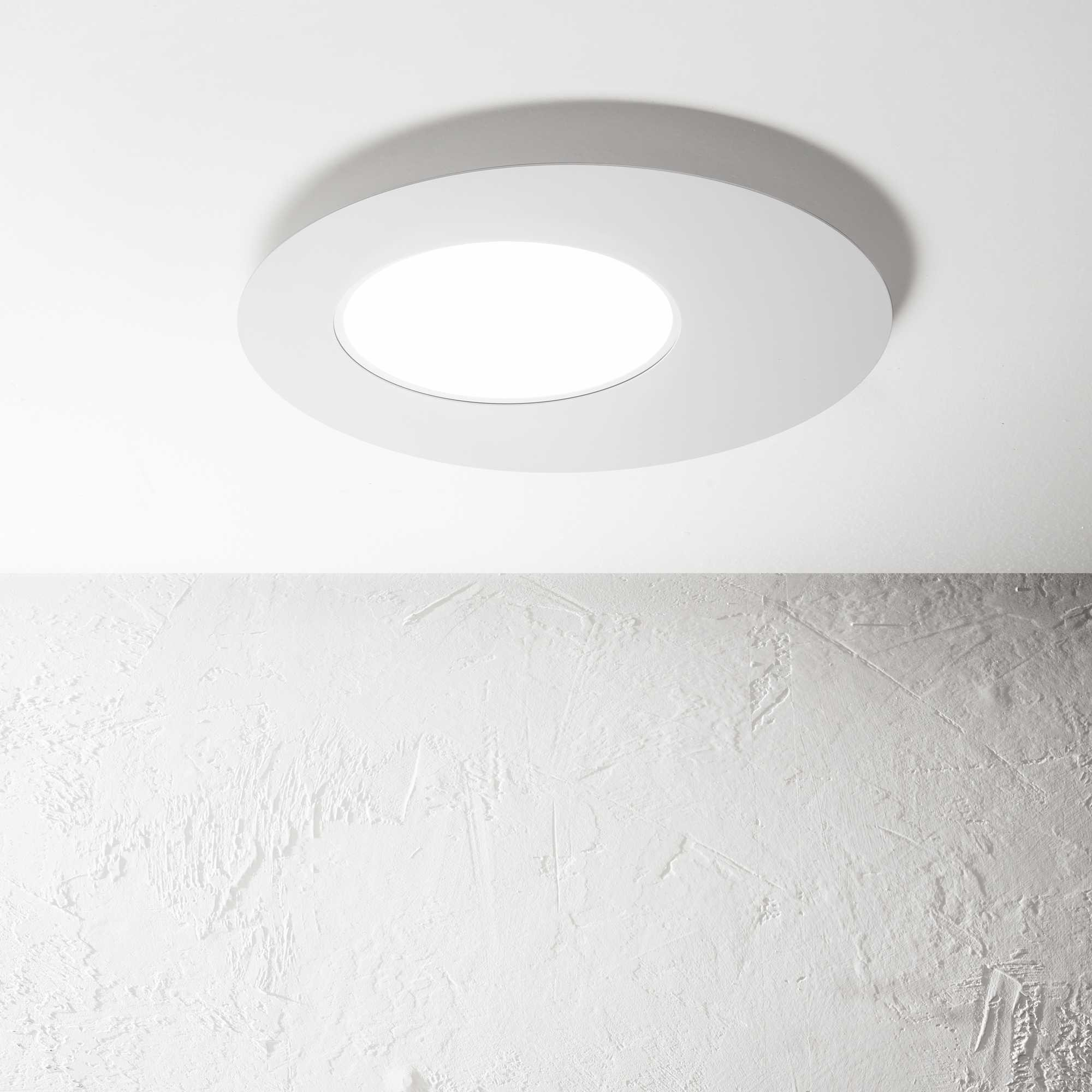Un lampada da soffitto rotonda con cornice bianca e centro illuminato.