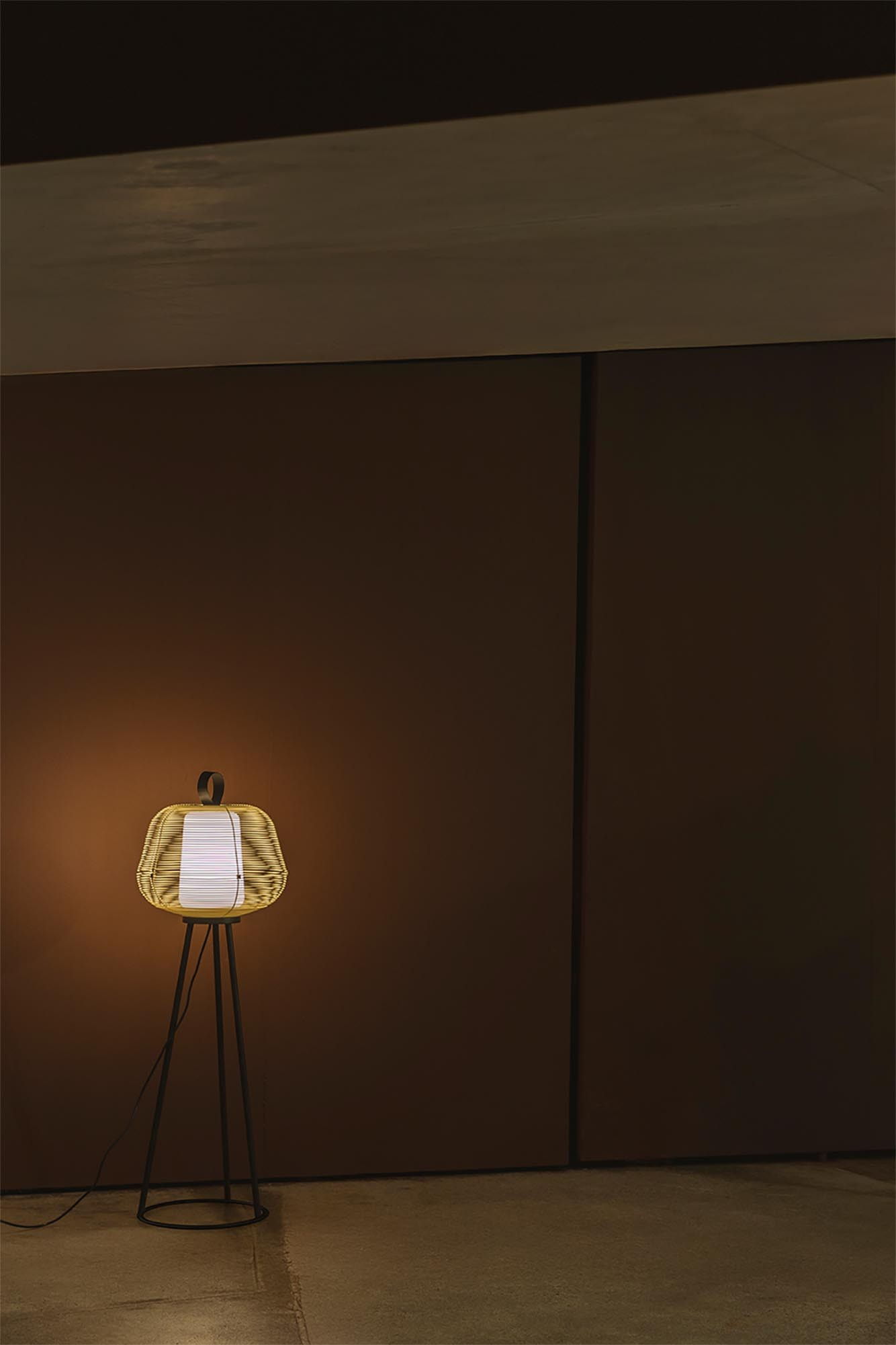 Lampada da terra decorativa con paralume intrecciato e base in metallo nero.