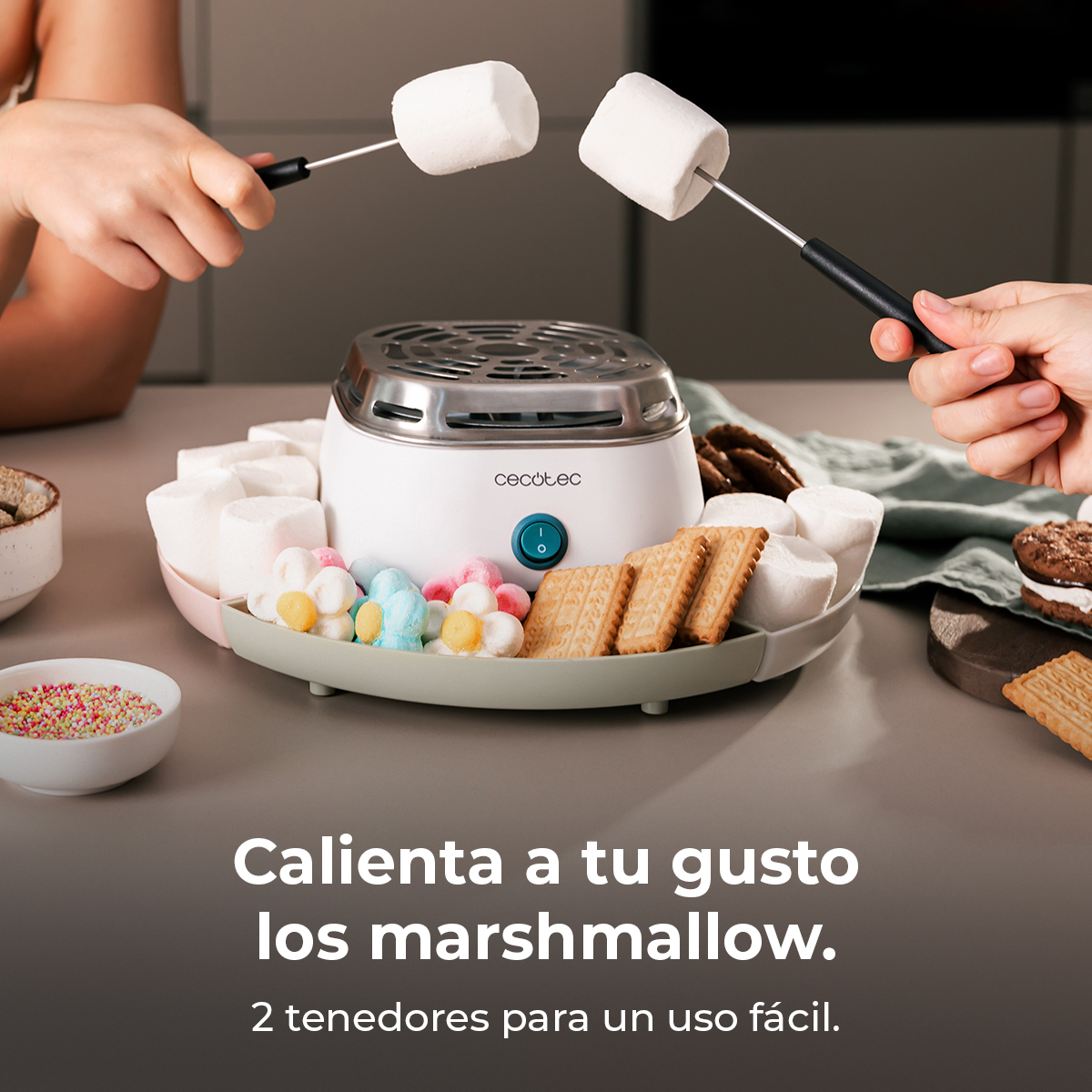 Due mani tengono spiedini con marshmallow su una macchina per marshmallow bianca con biscotti.