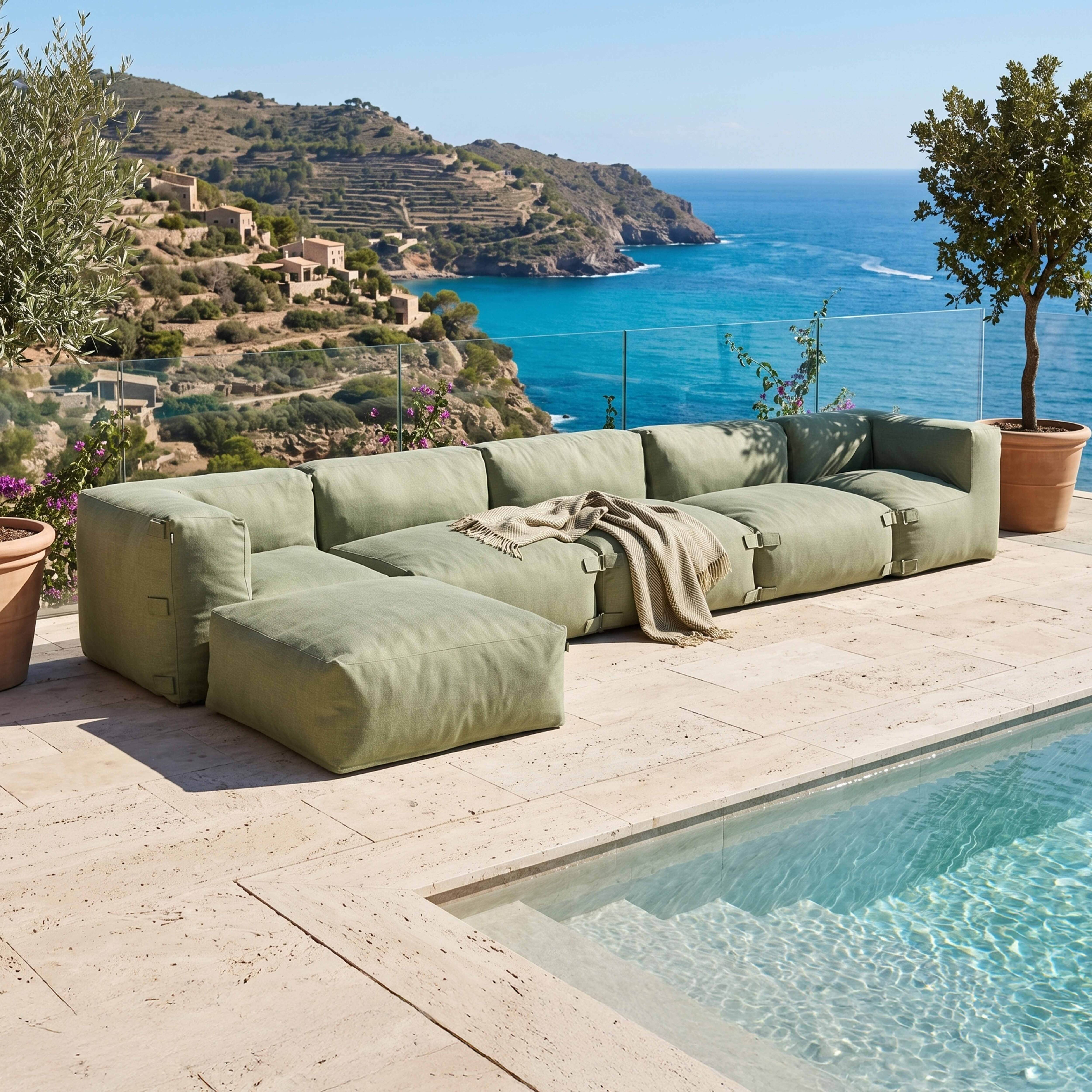 Grünes Ecksofa mit Decke am Pool mit Meerblick und Hügeln.