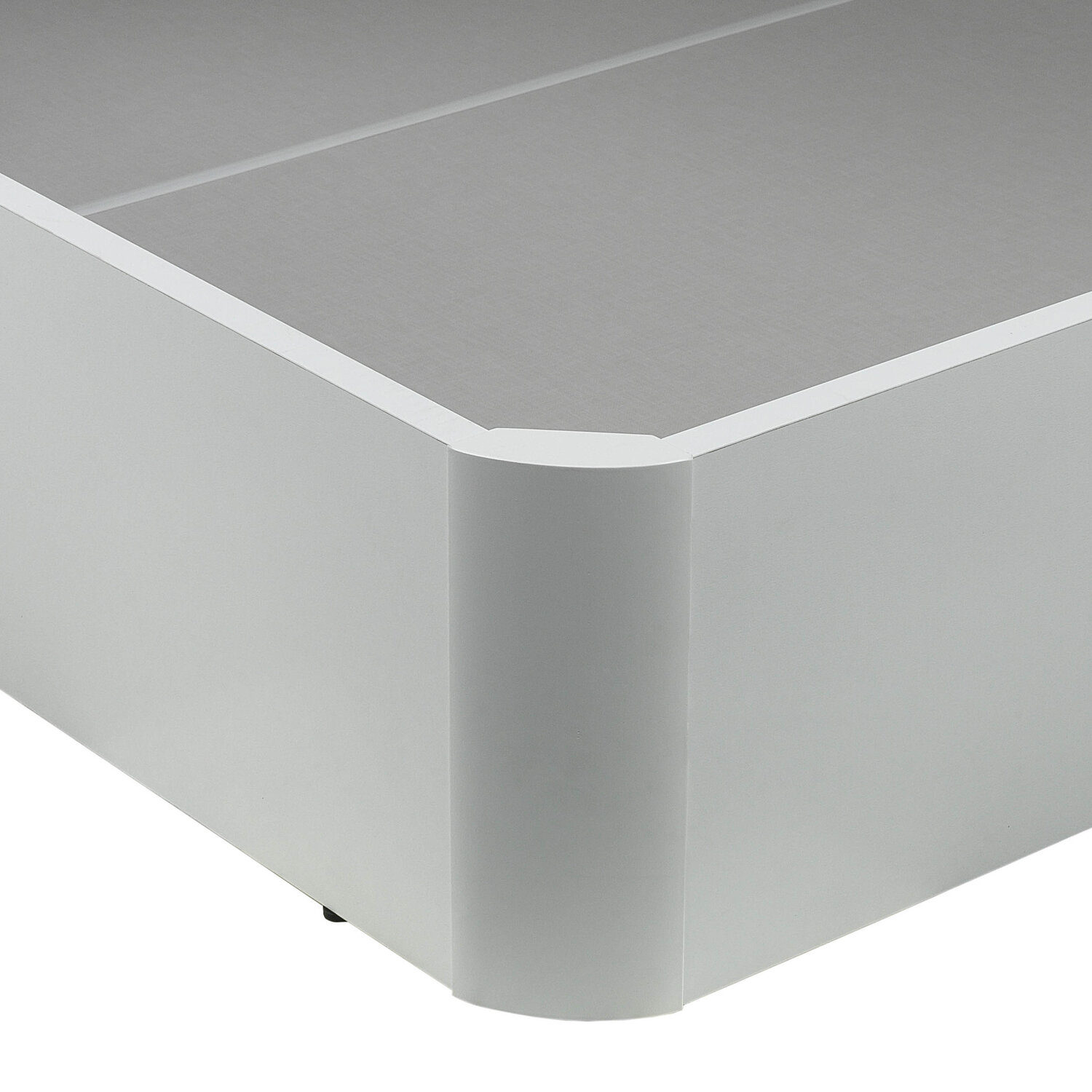 Un primer plano de una base de cama blanca con un detalle de esquina ligeramente redondeado.