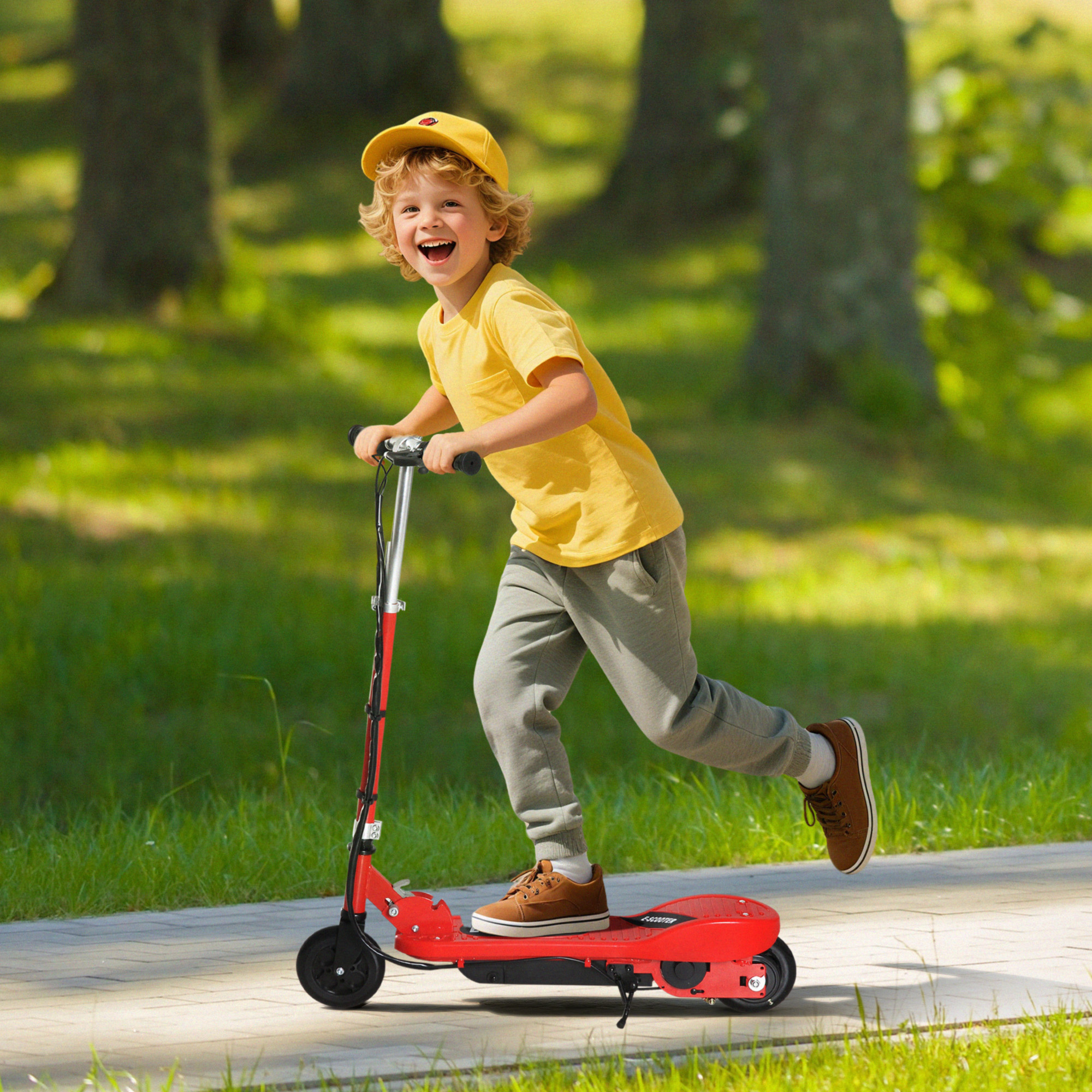 Un niño feliz con camisa amarilla monta un patinete eléctrico rojo en un camino pavimentado en un parque.