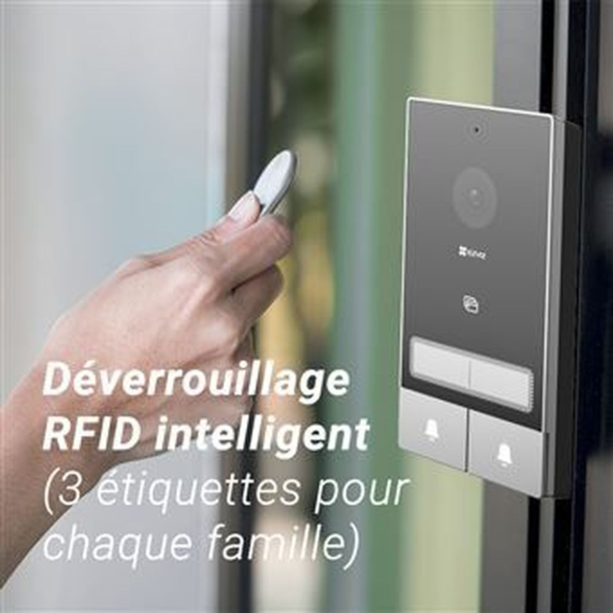 Una mano sostiene una etiqueta RFID frente a una cerradura de puerta con cámara.