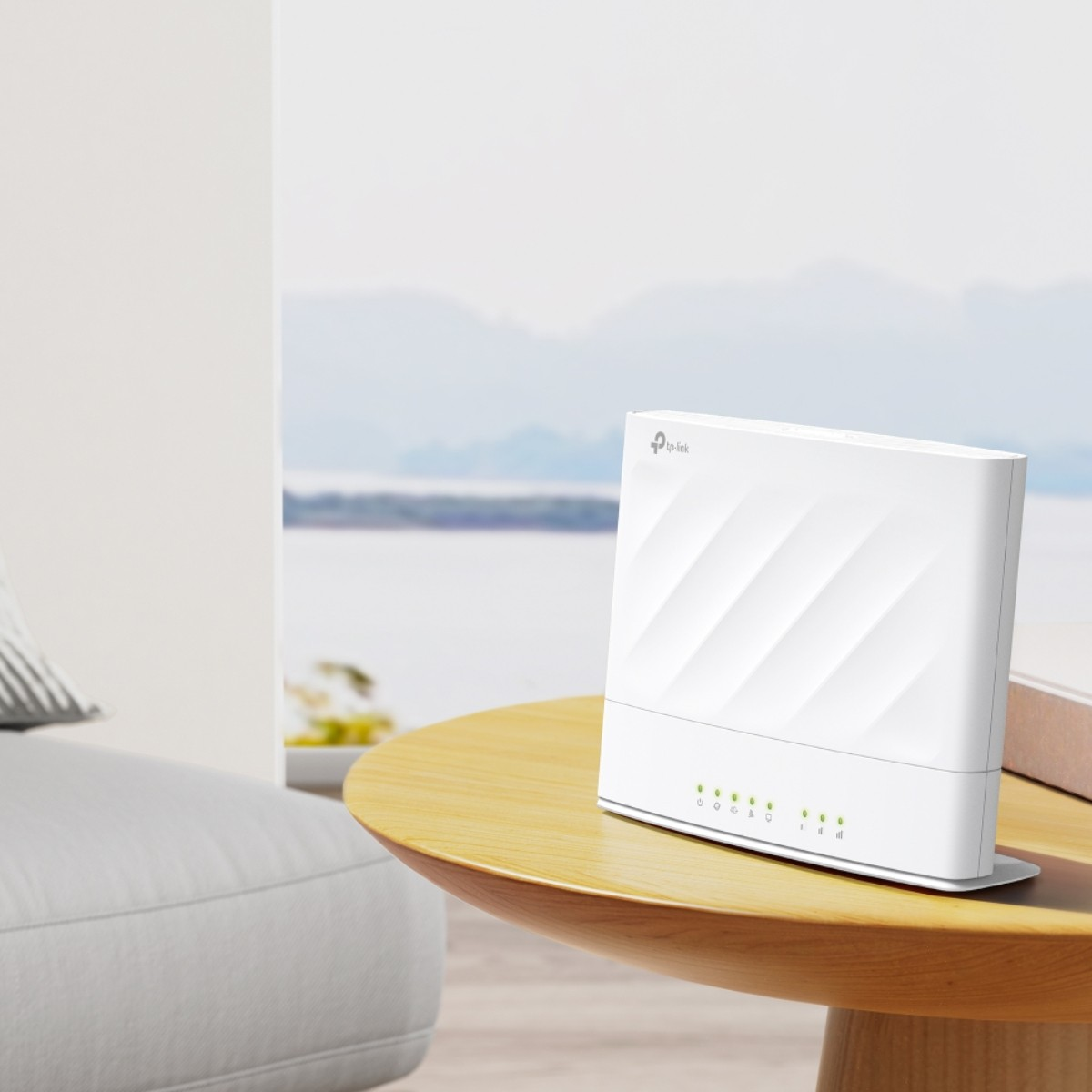 Un router TP-Link bianco siede su un tavolo di legno con vista sul mare.