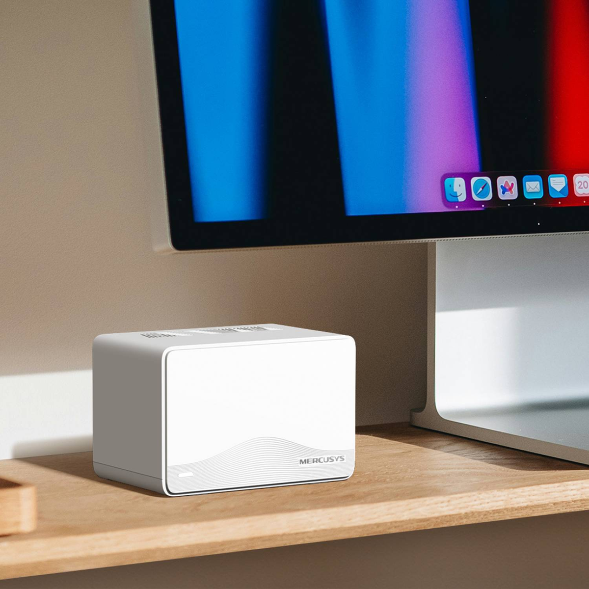 Un router blanco Mercusys se encuentra en un estante de madera junto a un monitor.