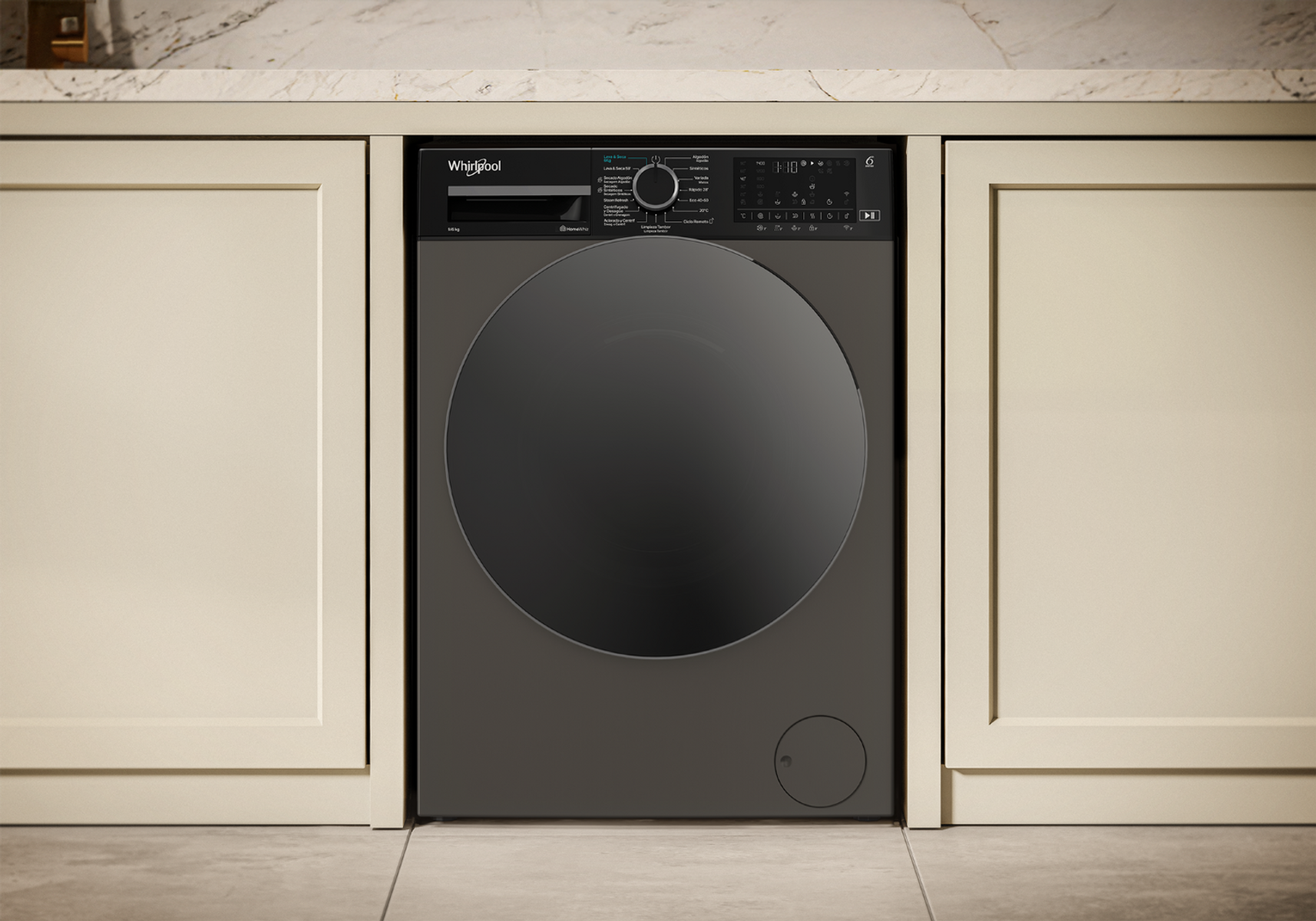 Una lavadora Whirlpool gris con puerta negra, encastrada en muebles color crema.