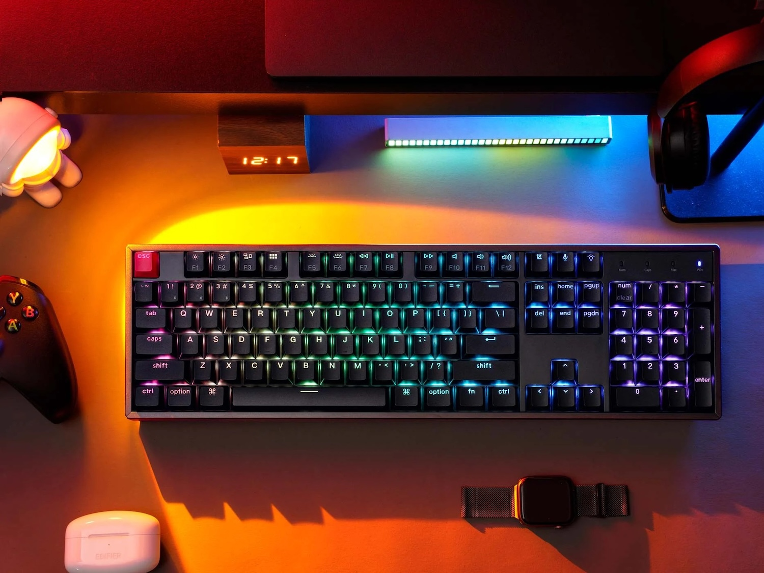 Czarna klawiatura mechaniczna z podświetleniem RGB stoi na biurku z akcesoriami do gier.