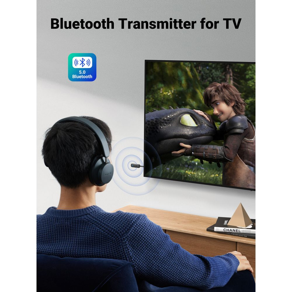 Kulaklıklı erkek TV izliyor. Bluetooth verici onları bağlıyor.