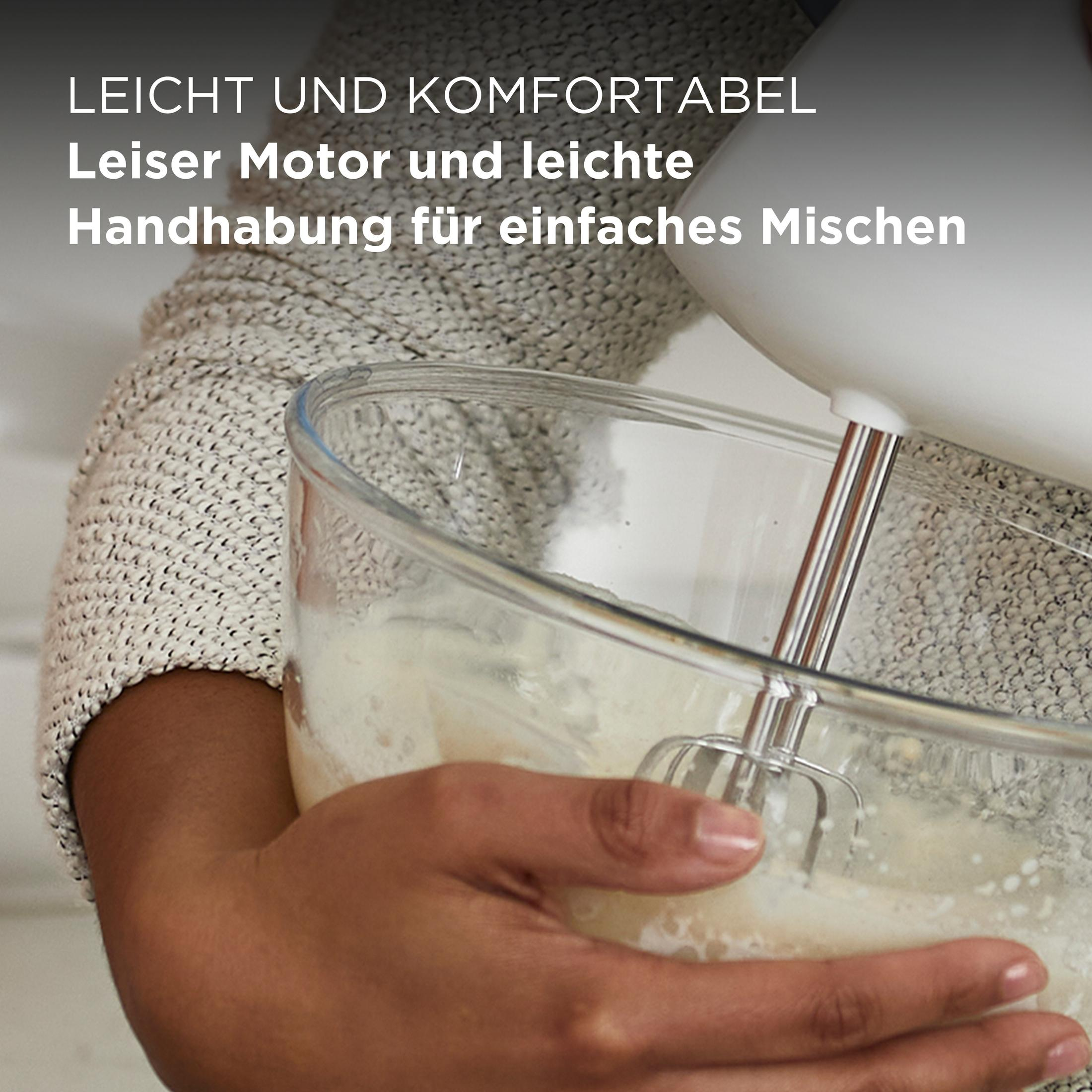 Een persoon mixt ingrediënten in een glazen kom met een witte handmixer.