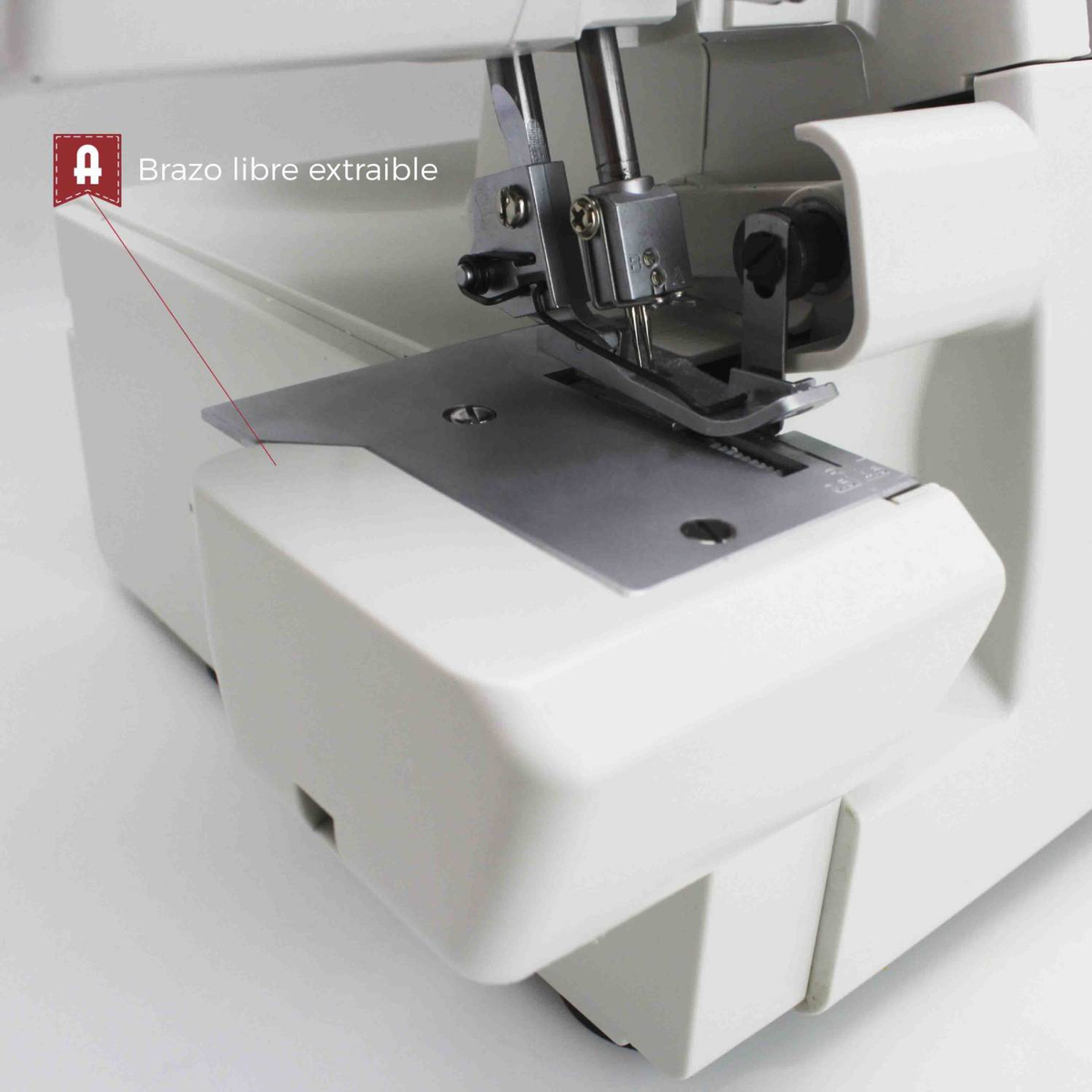 Primer plano de la aguja, prensatelas y placa metálica de una máquina de coser.
