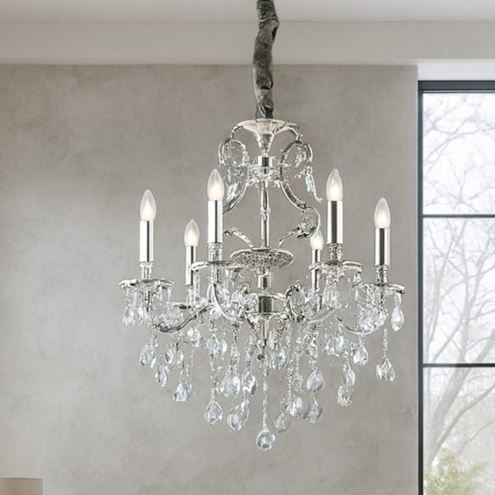 Un lampadario d'argento con gocce di cristallo e sei lampadine a candela.