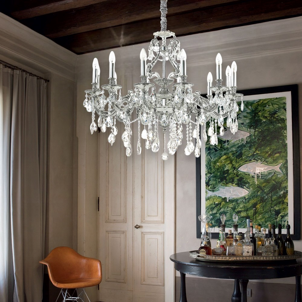 Un lampadario di cristallo è appeso sopra un tavolo rotondo con bevande.