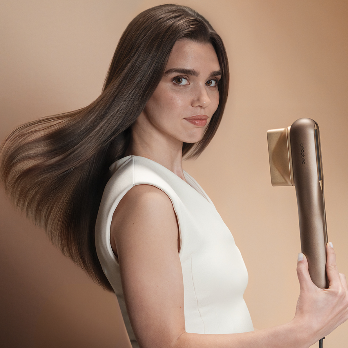 Donna con lunghi capelli castani, vestito bianco, tiene piastra dorata.