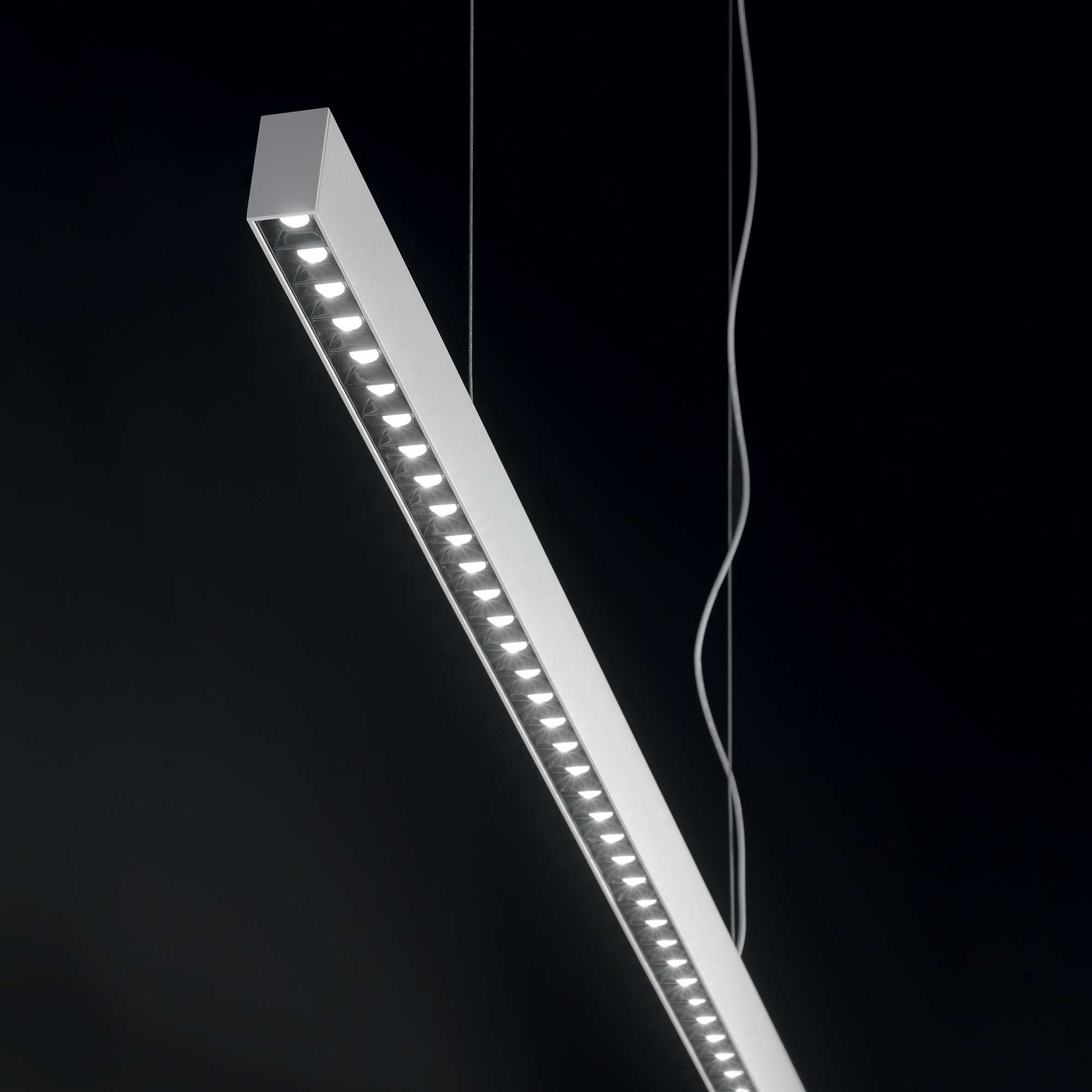 Un'elegante barra luminosa a LED bianca appesa su sfondo nero.