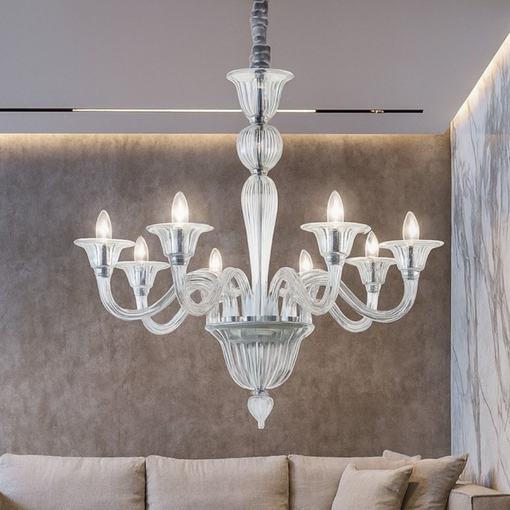 Un lampadario di vetro a otto bracci è appeso sopra un divano.