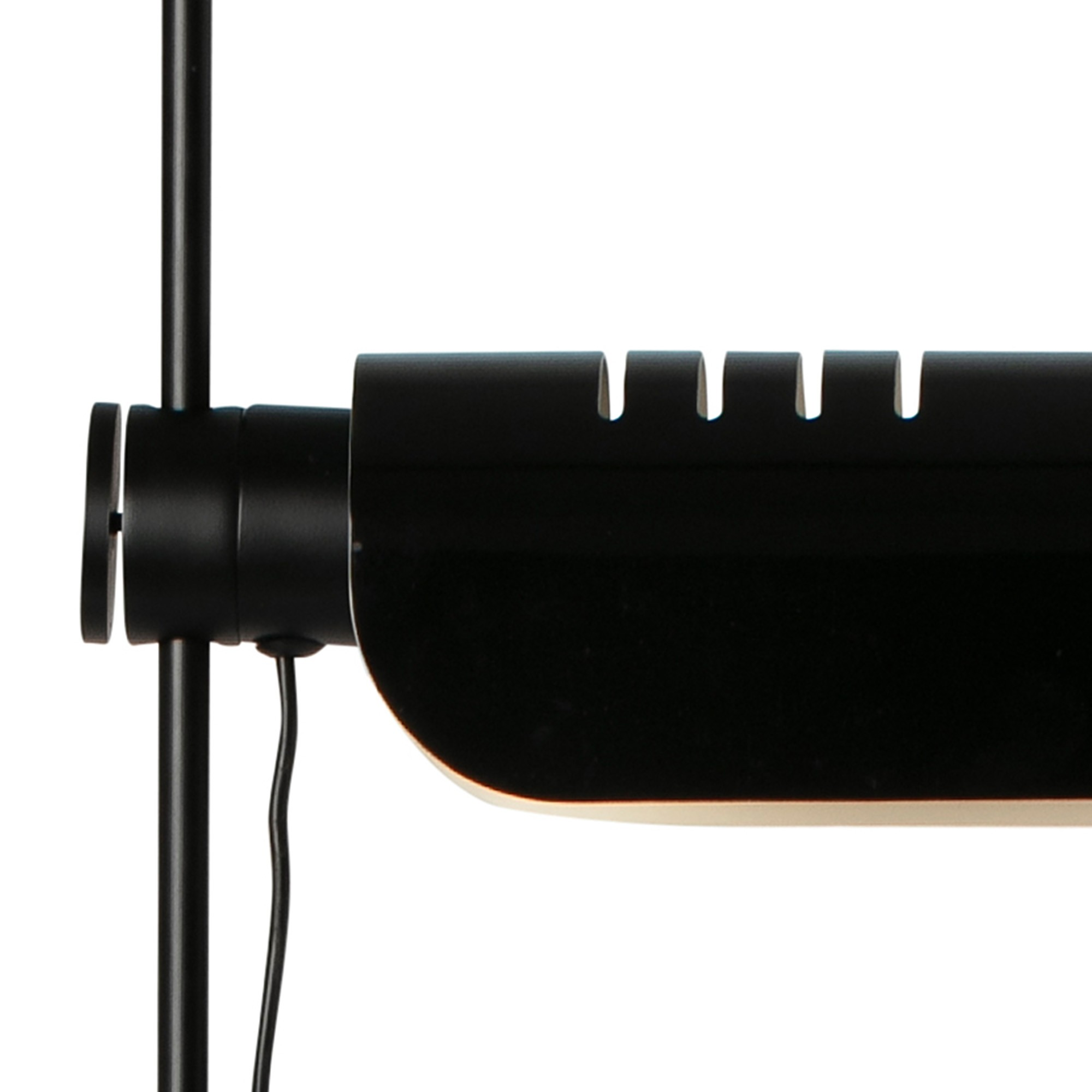 Primo piano di una lampada nera con fessure in alto e un cavo.