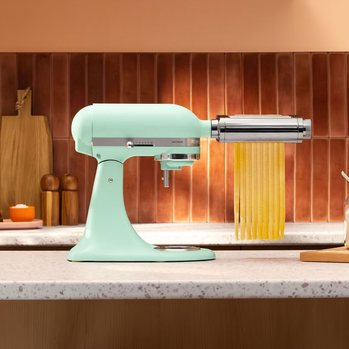 Taze fettuccine yapan, makarna silindir aparatı takılı, nane yeşili KitchenAid mikser.