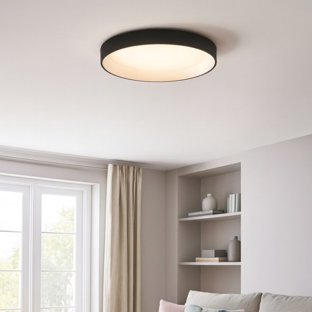 Una plafoniera rotonda con cornice nera illumina una stanza con finestra e scaffale.