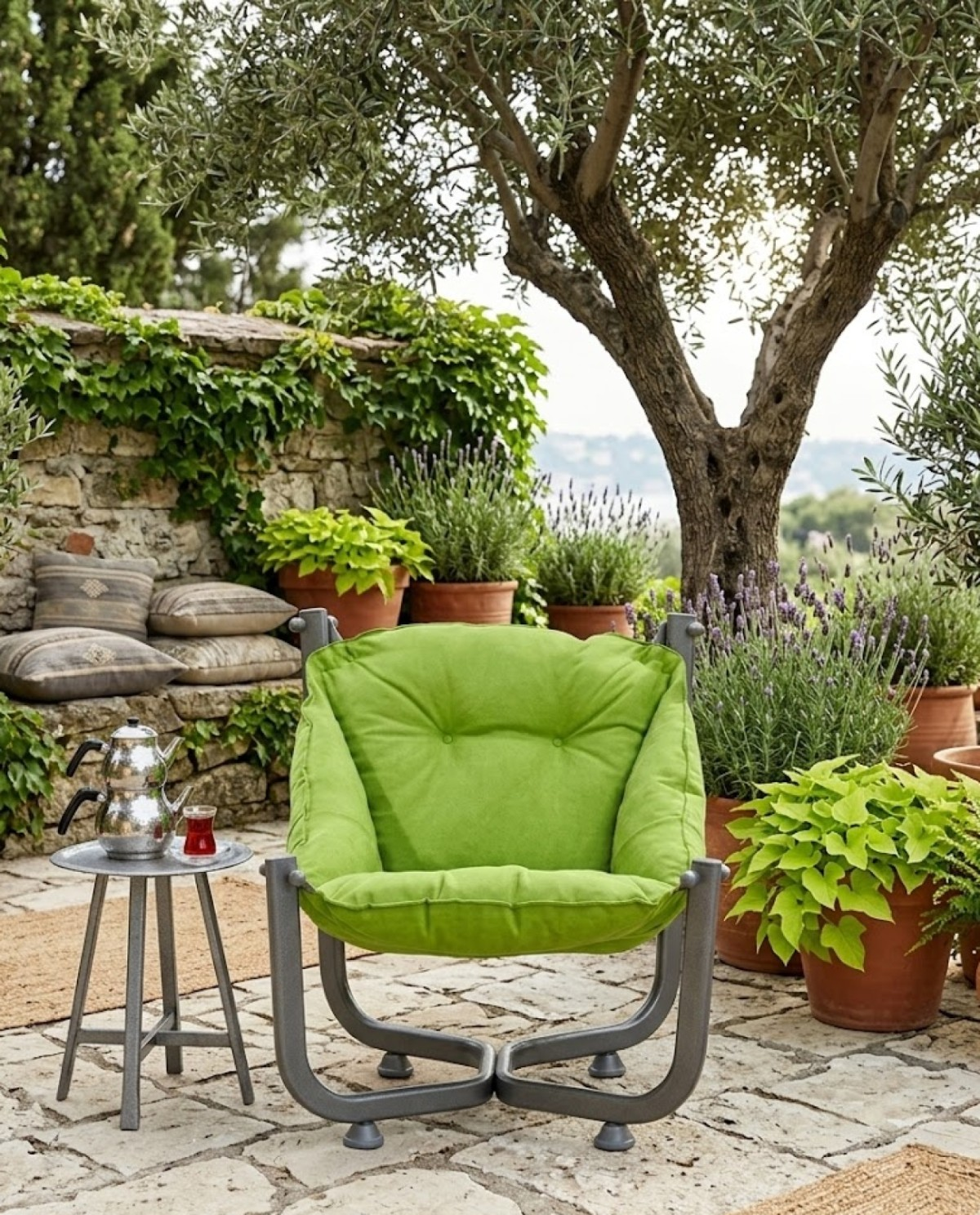 Yeşil koltuk dış mekanda, demlik ve bardaklı bir masanın yanında.