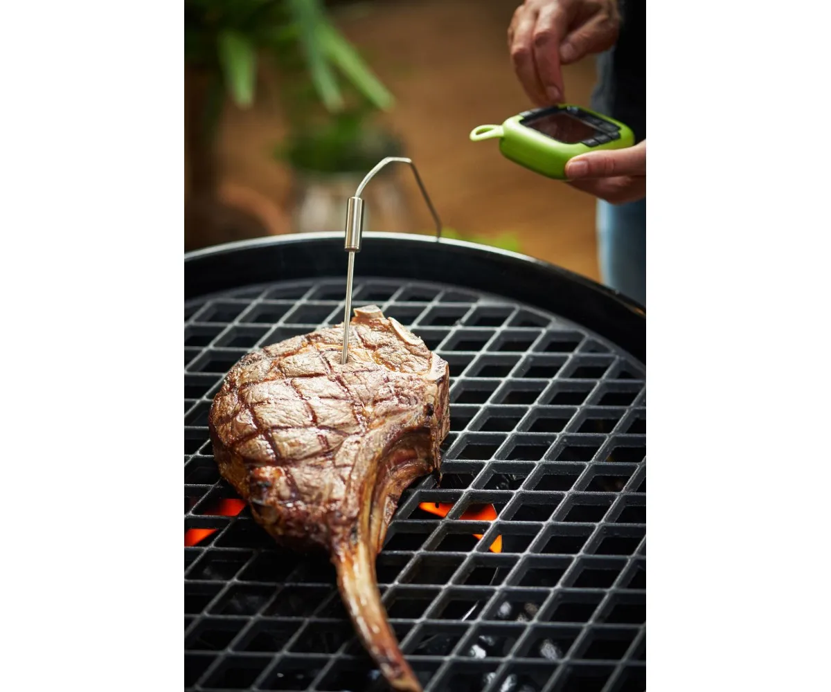 Tomahawk bifteği ızgarada pişiyor, termometre takılı.