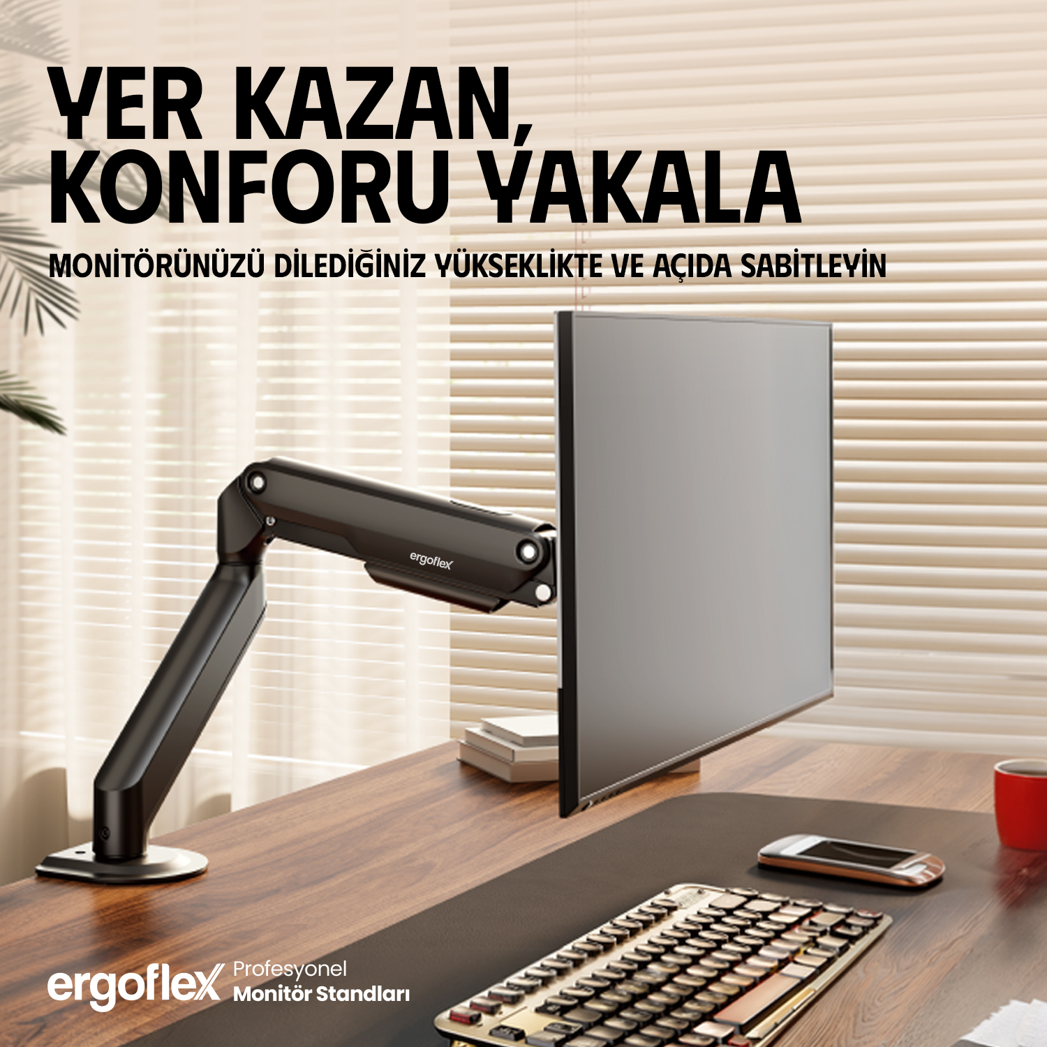 Siyah monitör kolu, klavyeli ve telefonlu bir masanın üzerinde gri ekran tutar.
