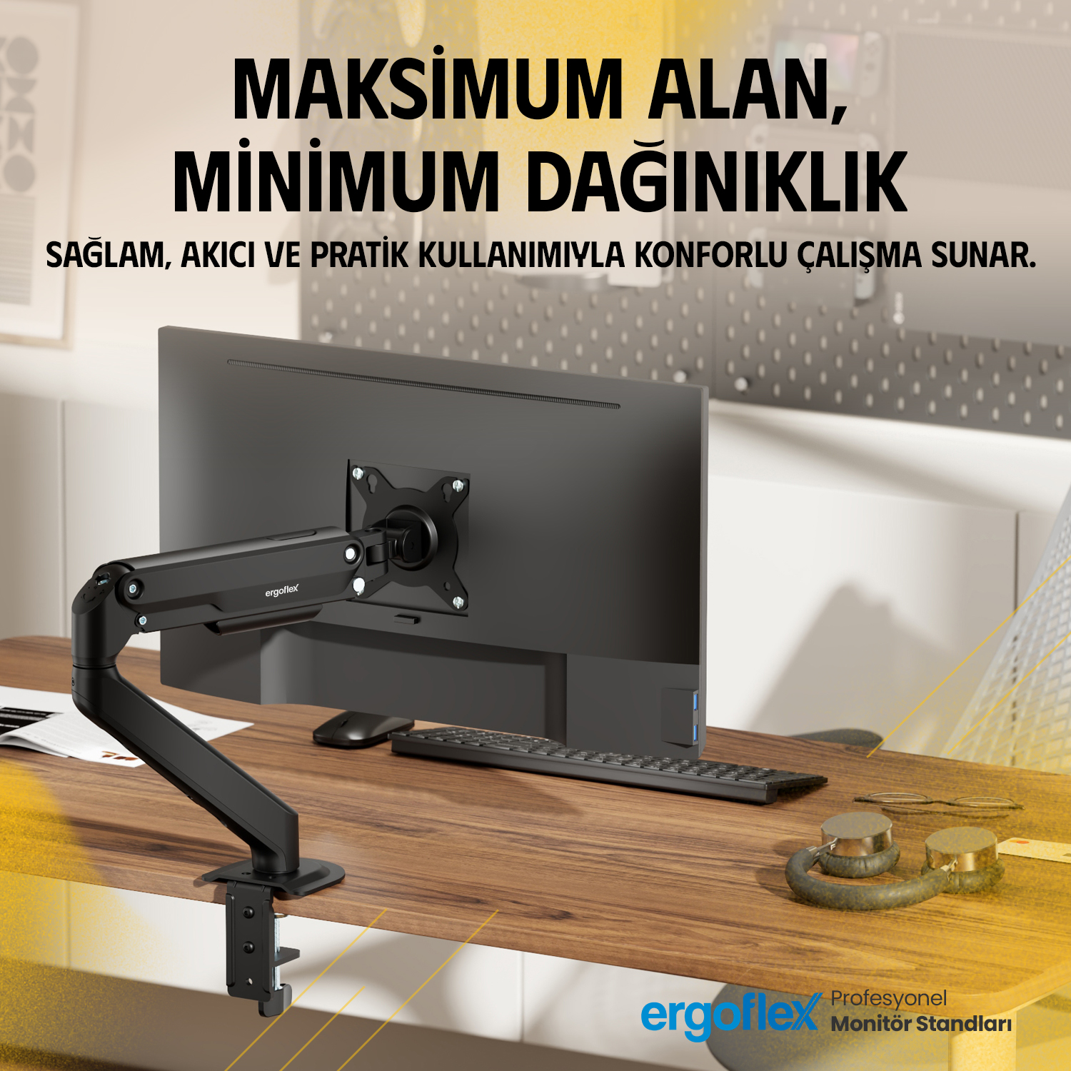 Siyah monitör kolu, klavyeli ve kulaklıklı bir masada siyah monitörü tutuyor.