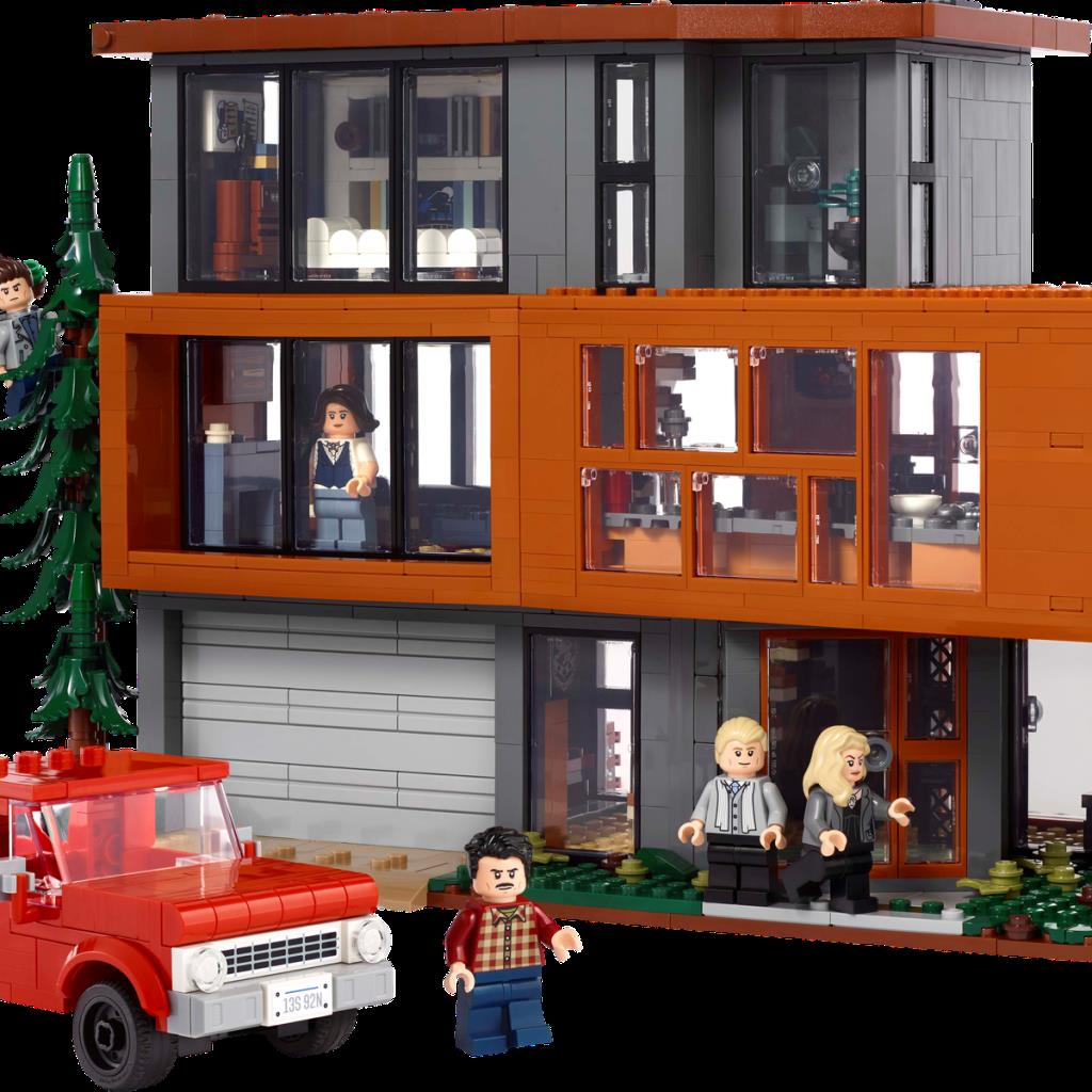 Ein modernes Haus aus Lego mit rotem Pickup, Figuren und Bäumen.