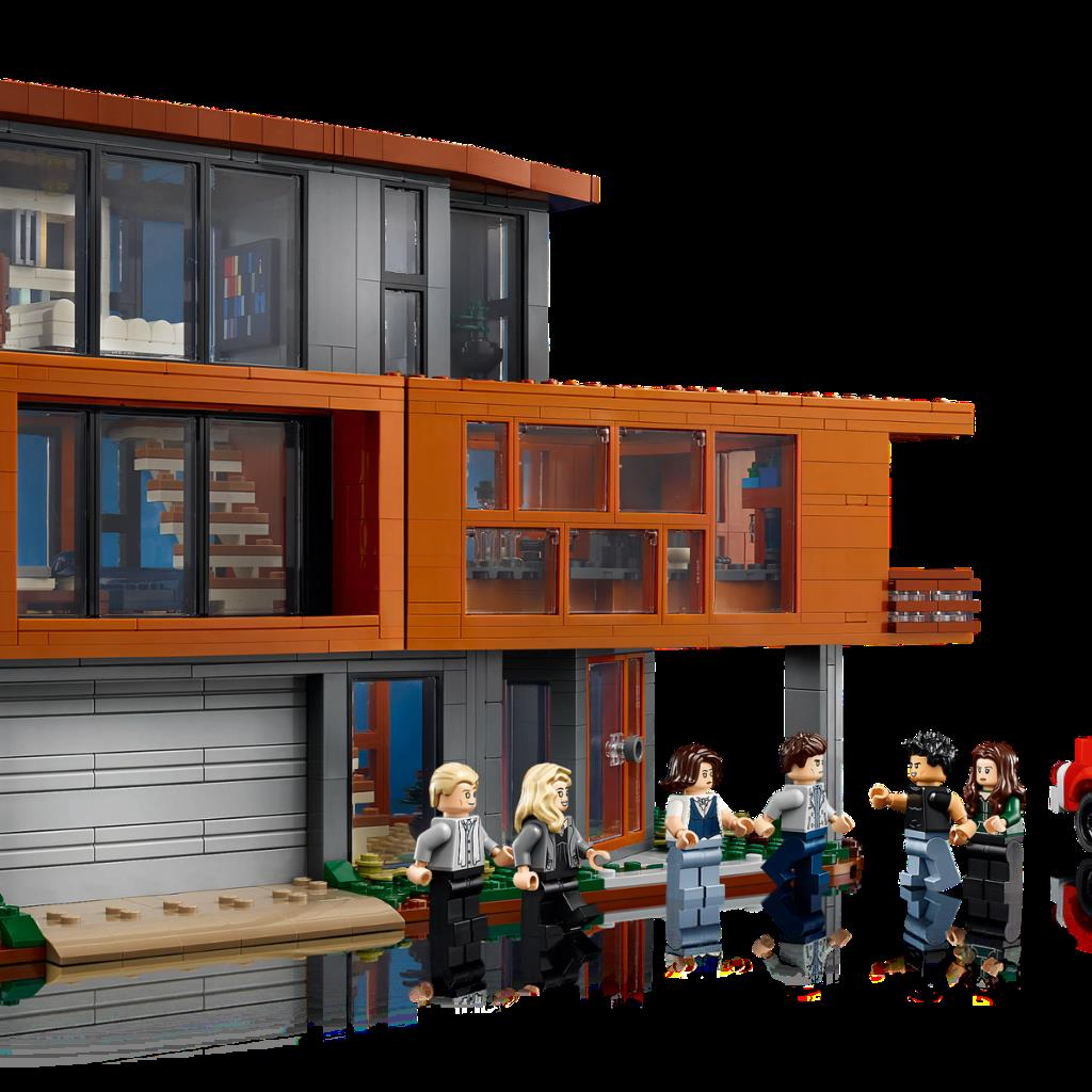 Ein Lego-Haus mit Fenstern, Garage und sechs Figuren davor.