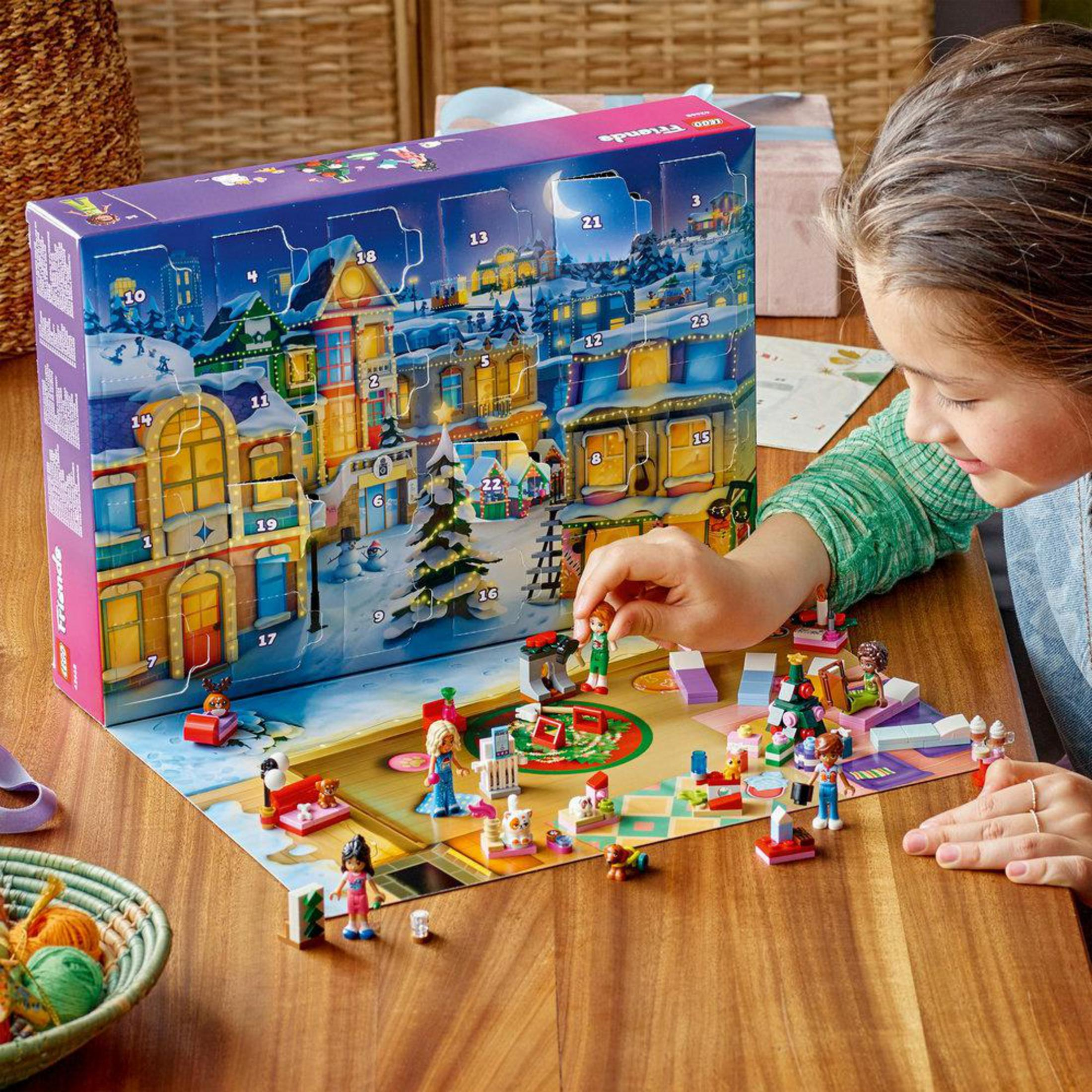 Een meisje speelt met een Lego adventskalender met een winterdorp-scène.