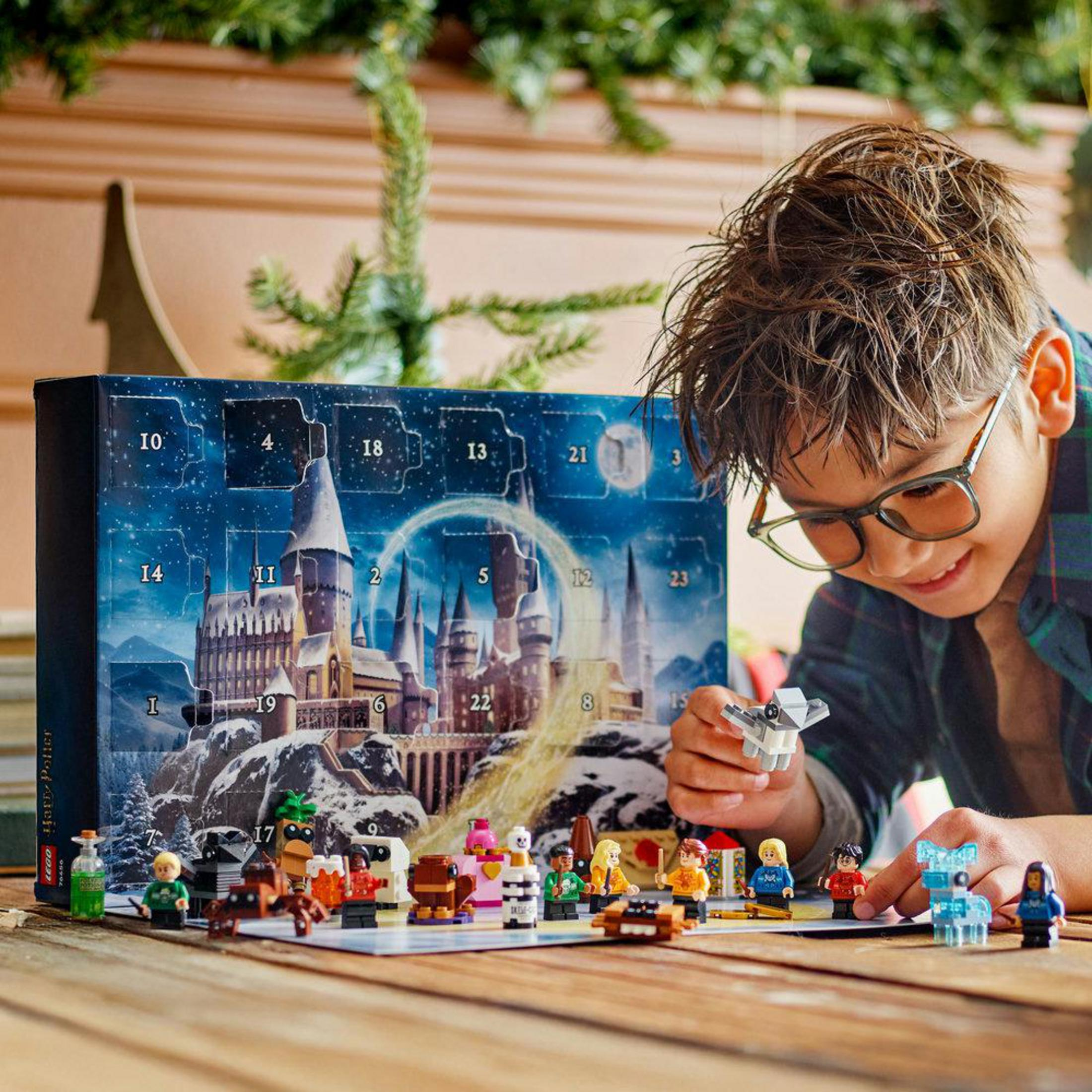 Un ragazzo gioca con le minifigure LEGO davanti a un calendario dell'Avvento di Harry Potter.