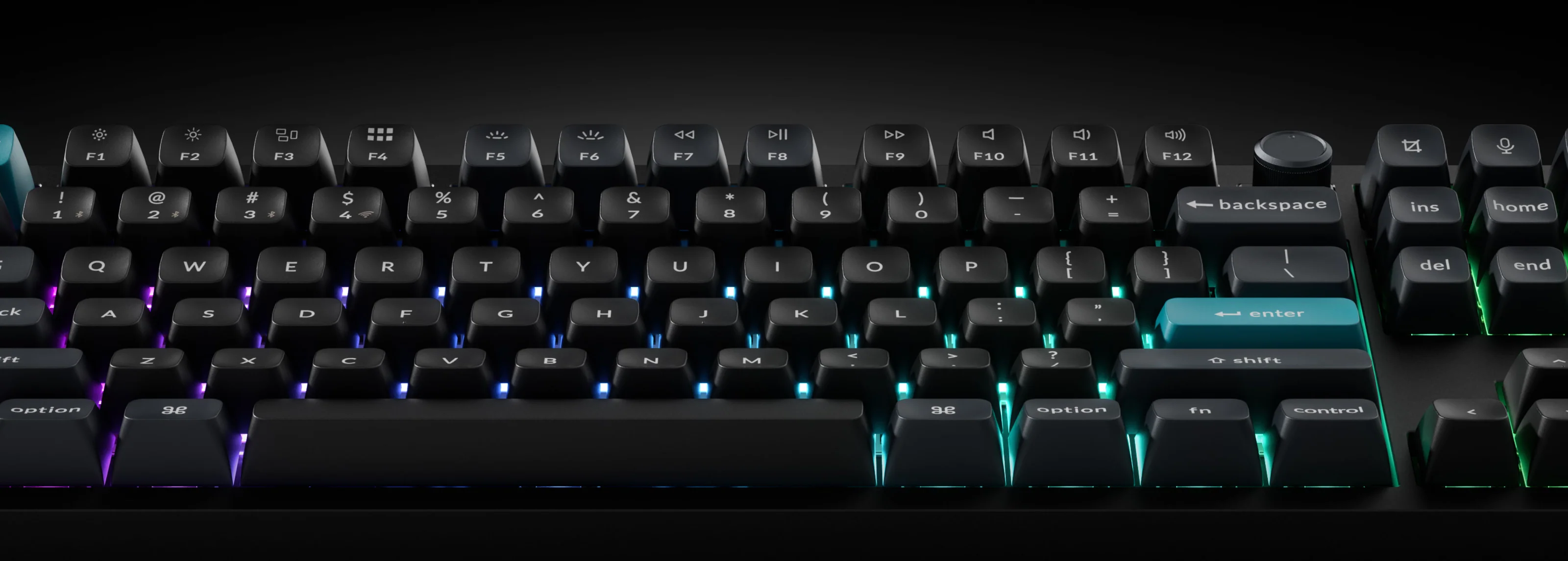 Zbliżenie czarnej klawiatury z podświetleniem RGB pod klawiszami.
