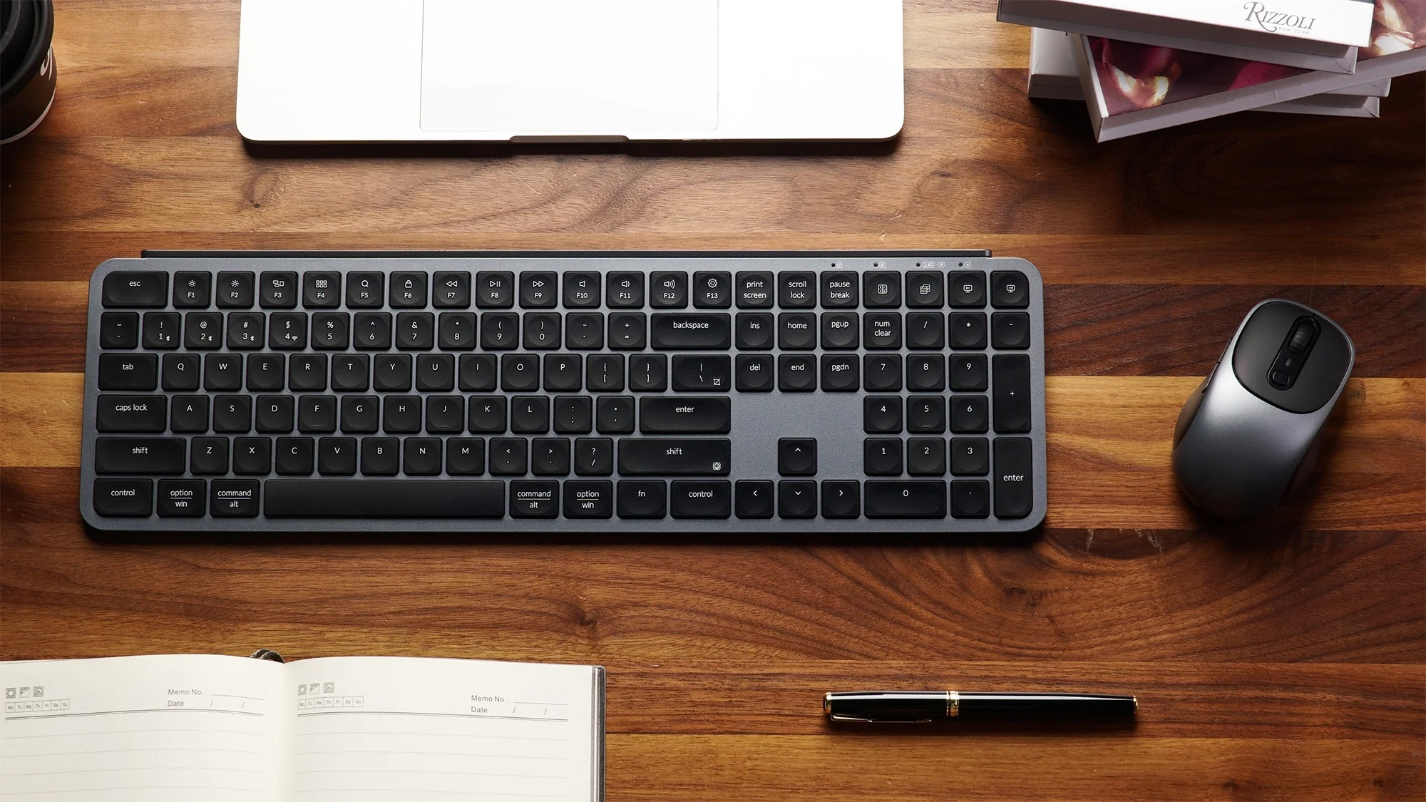 Szara klawiatura i mysz na drewnianym biurku obok laptopa.