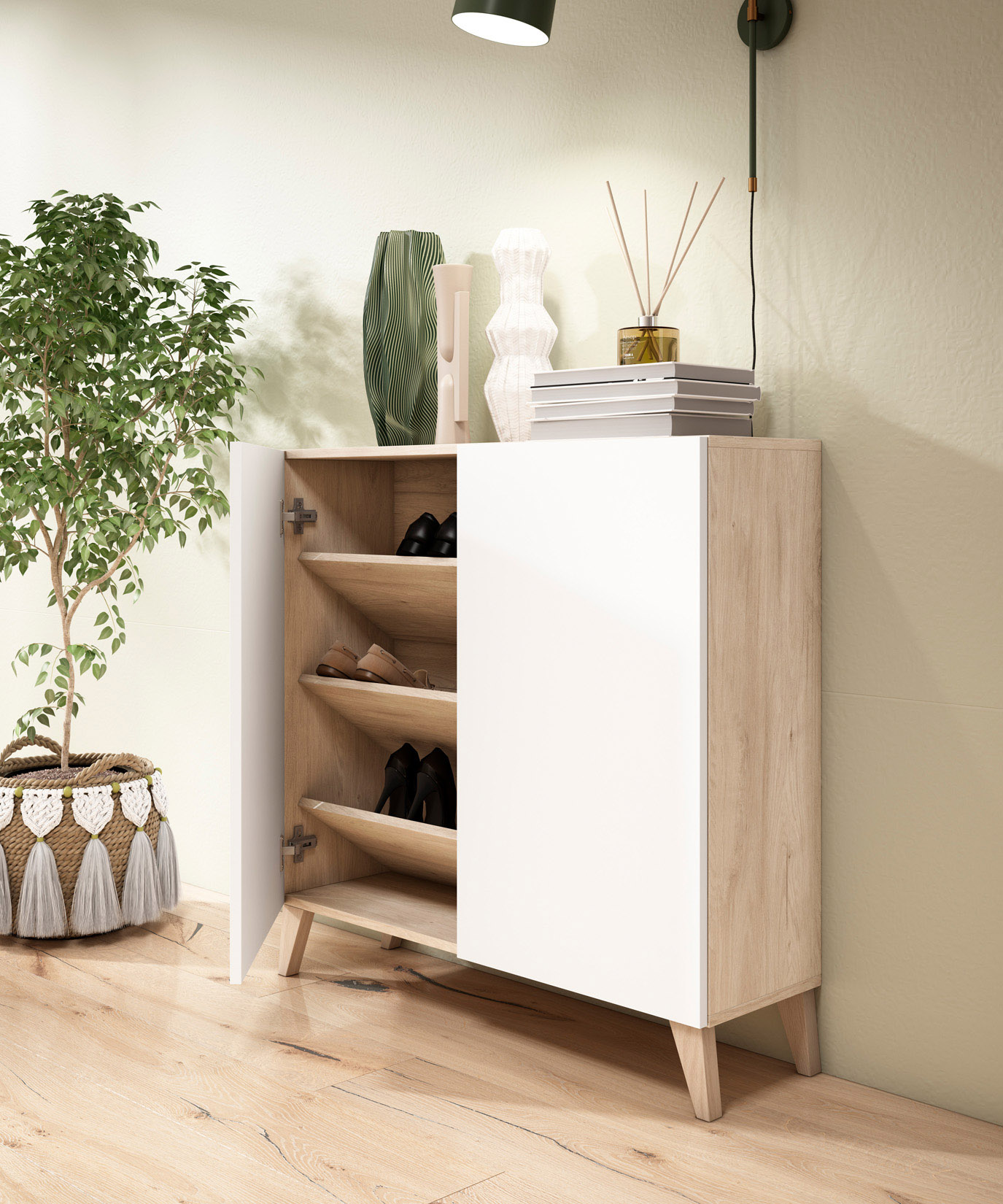 Un zapatero blanco con detalles de madera, una planta y objetos decorativos.