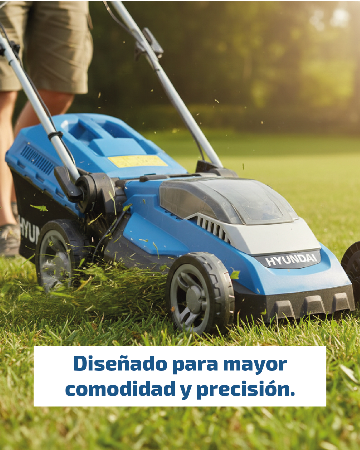 Un cortacésped azul es usado por una persona en un césped verde.