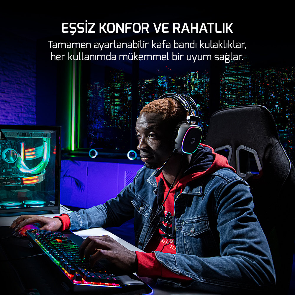 Kulaklıklı bir adam parlak bir bilgisayarın önünde oturuyor.