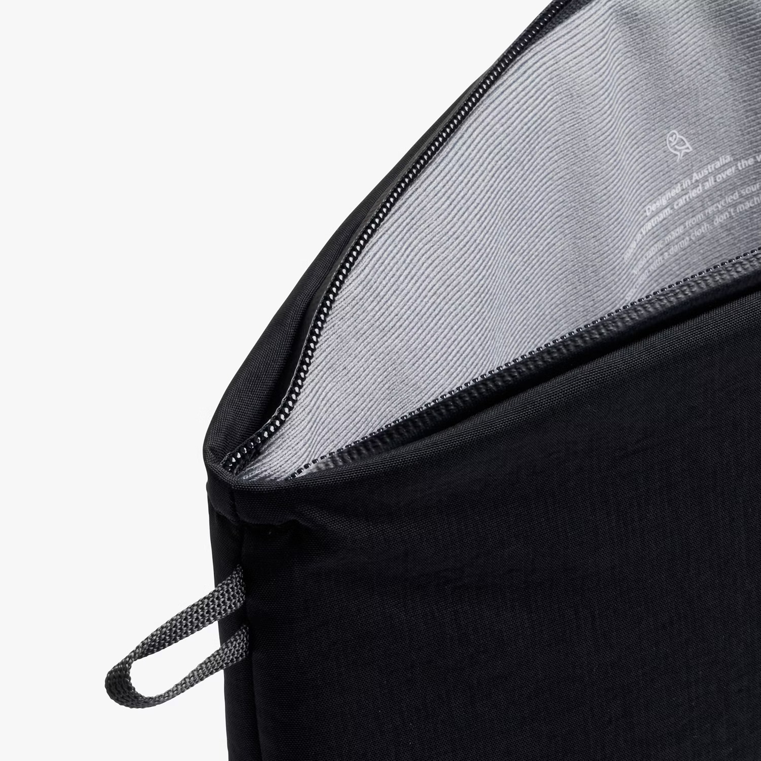 Borsa nera con cerniera aperta e manico ad anello. L'interno ha testo.