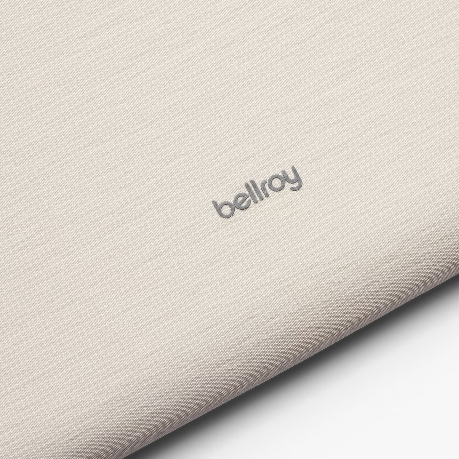 Tessuto color chiaro con un discreto logo "bellroy" grigio.