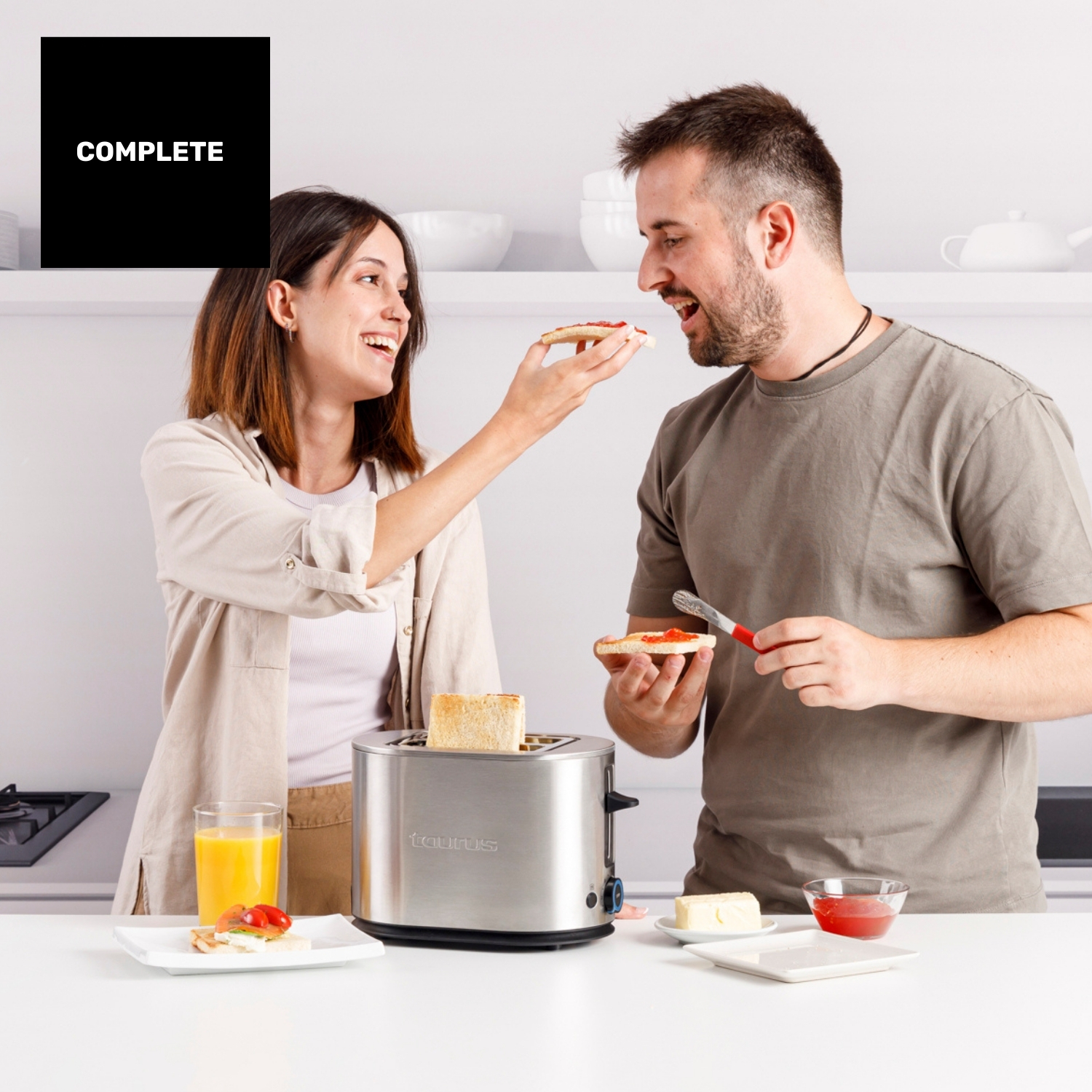 Un hombre y una mujer hacen tostadas en una cocina, preparando el desayuno.