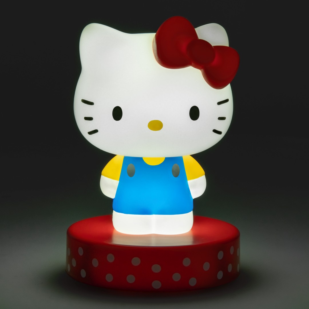 Podświetlana figurka Hello Kitty z czerwoną kokardą, żółtą bluzką i niebieskimi ogrodniczkami.
