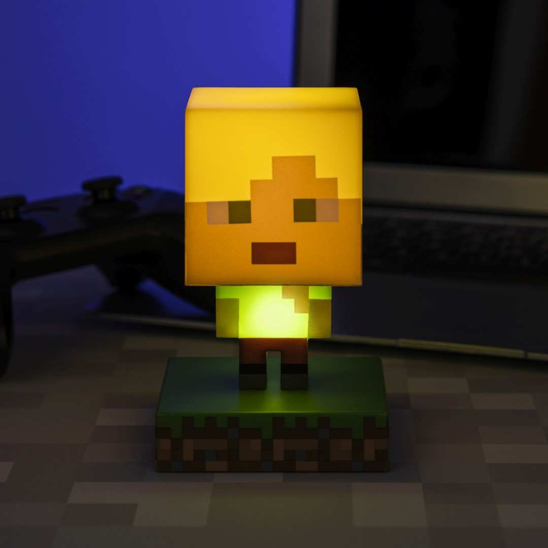 Świecąca postać z Minecrafta z żółtą głową, zieloną koszulą i brązowymi spodniami na trawiastym postumencie.