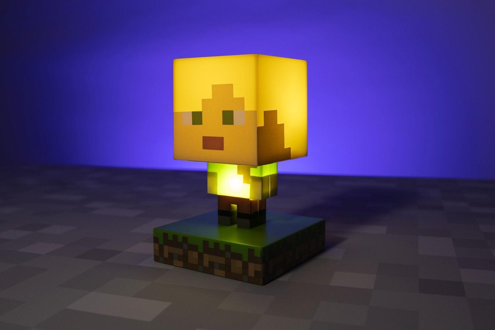 Świecąca postać z Minecraft z żółtą głową i zielonym tułowiem na podstawie z bloku trawy.